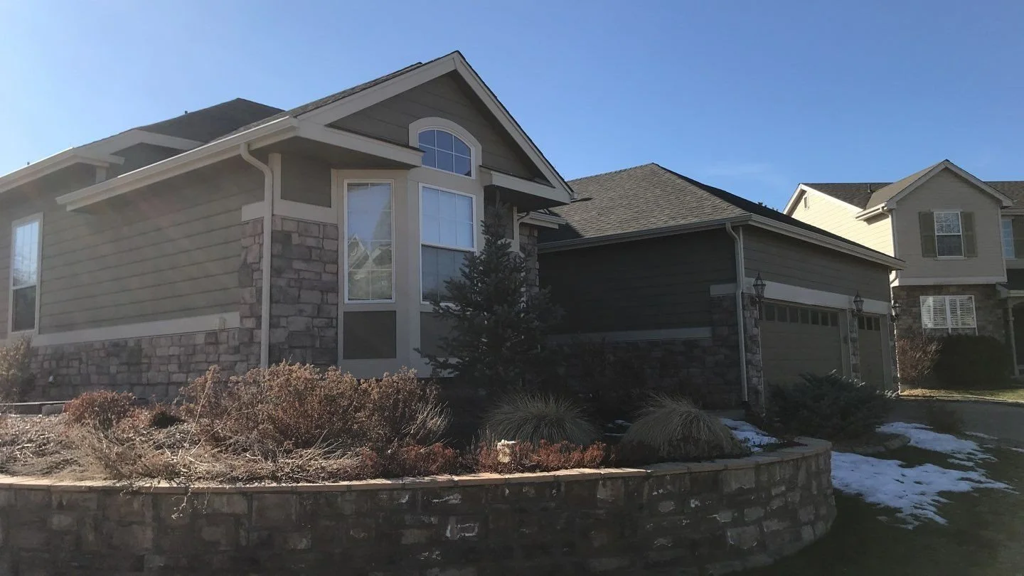 Brick and siding home with almond seamless gutters and downspouts in the Denver Metro area.