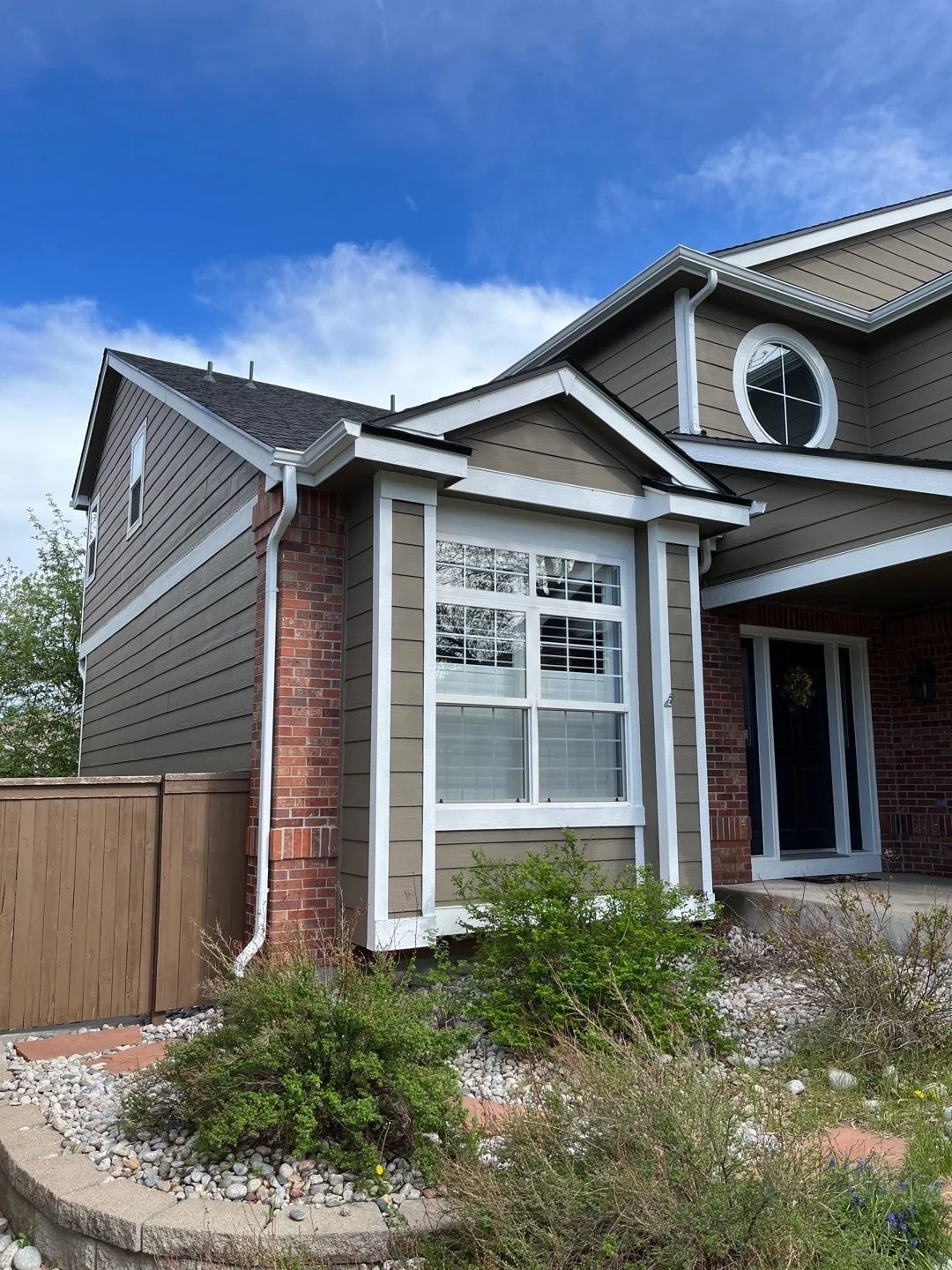 Custom seamless gutters installed around a projecting front window and adjoining rooflines.