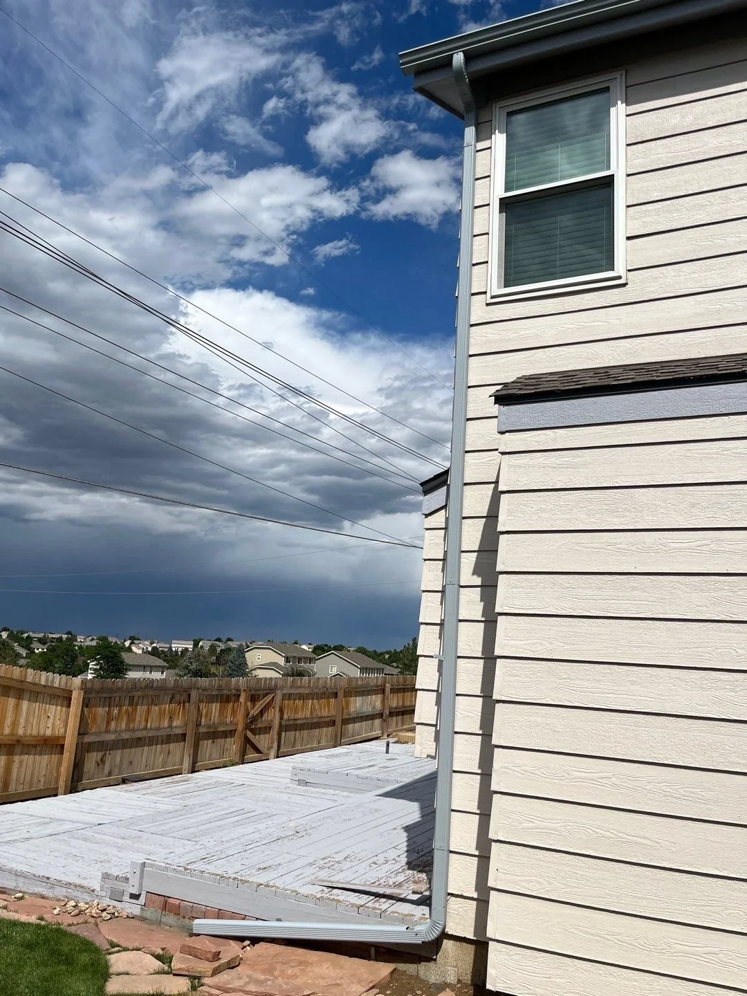 Downspout installed along the side wall of a two-story home in the Denver Metro area.