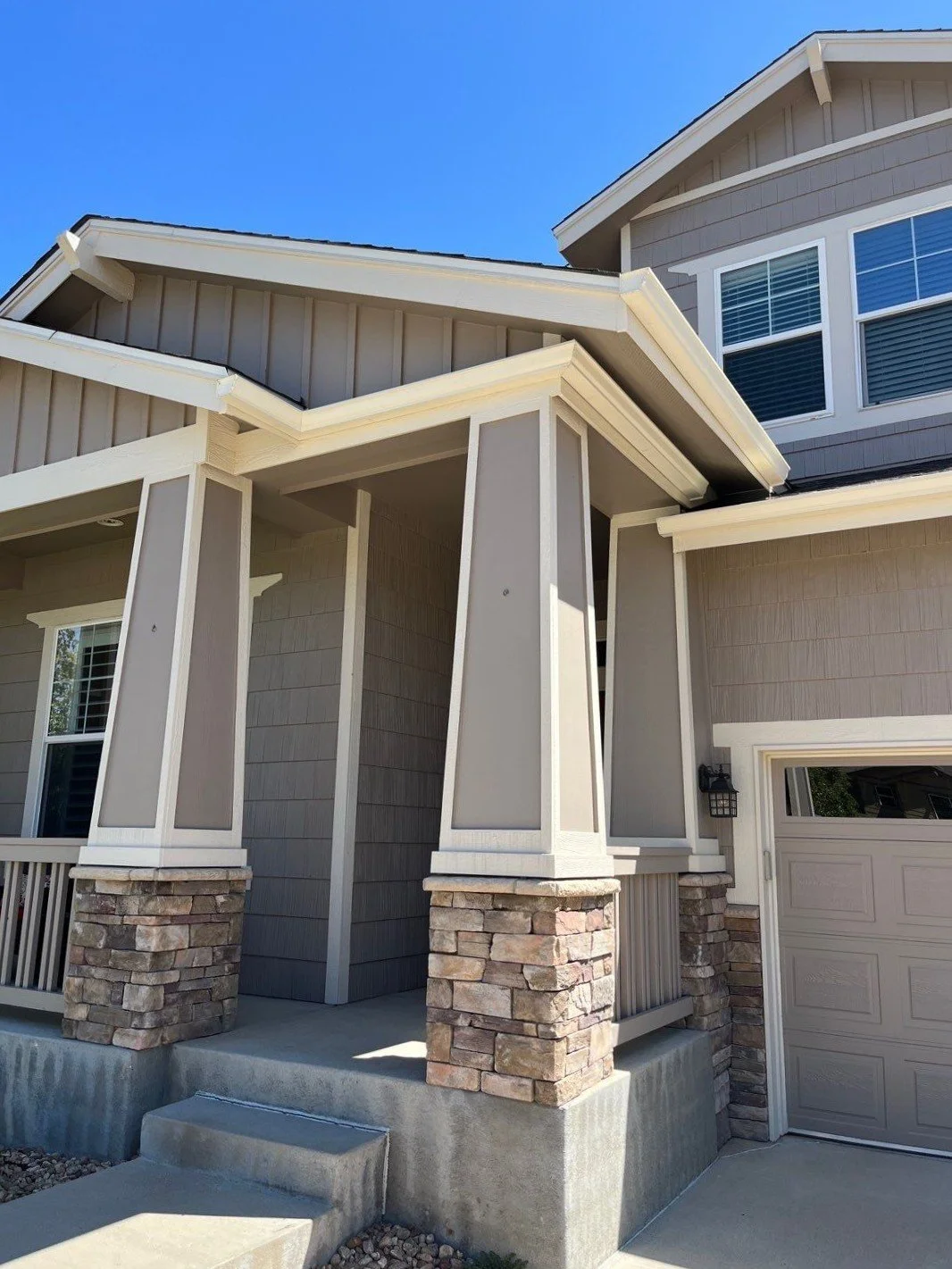 A new seamless gutter installation finishes the covered entry while helping protect the stone columns and front walkway.