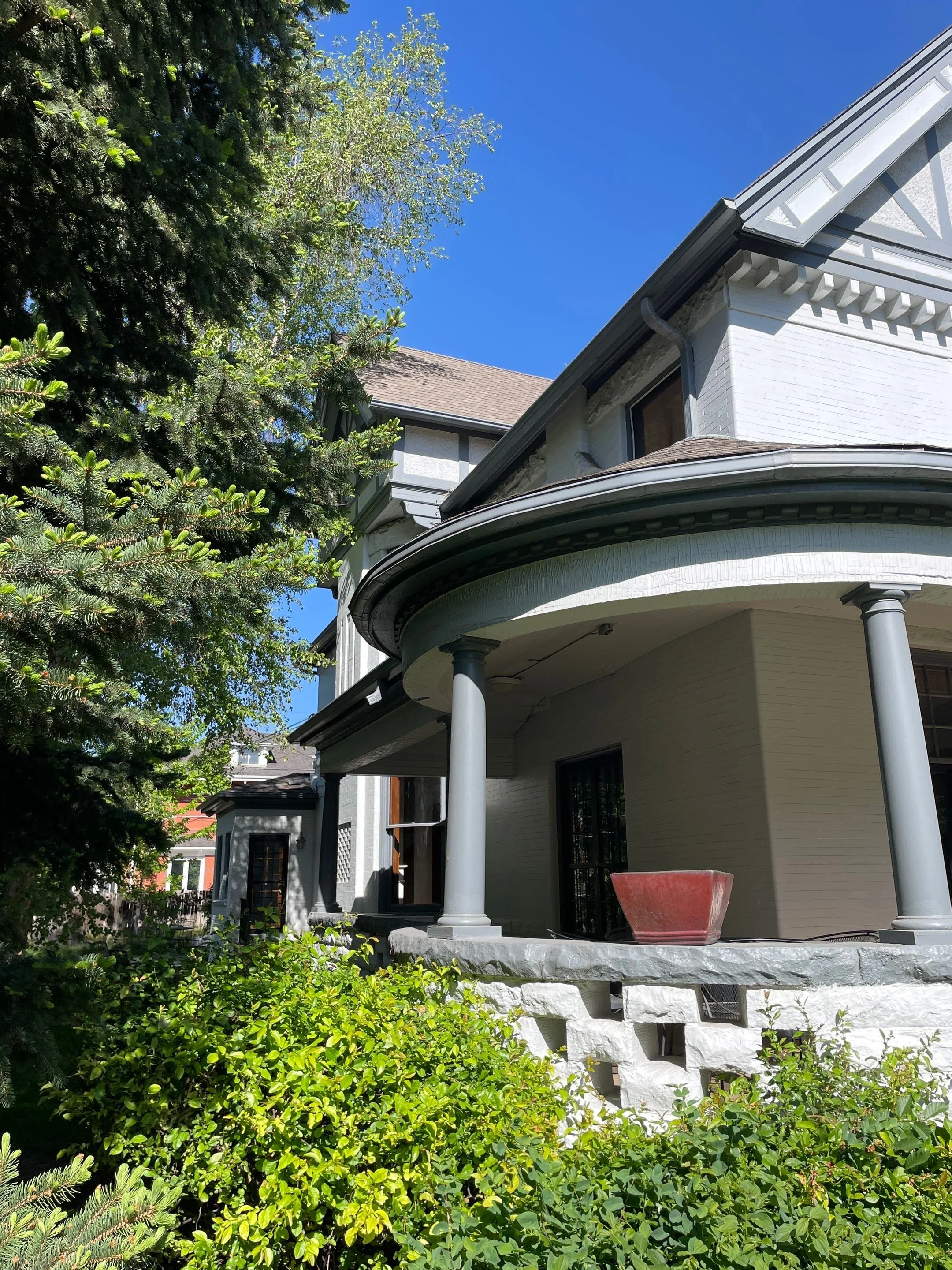 Aging gutter system around the home’s rounded porch roof before replacement.