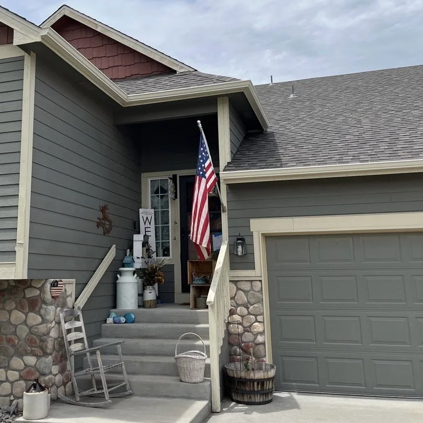 Home entry and garage with seamless gutters and downspouts installed along the front roofline.