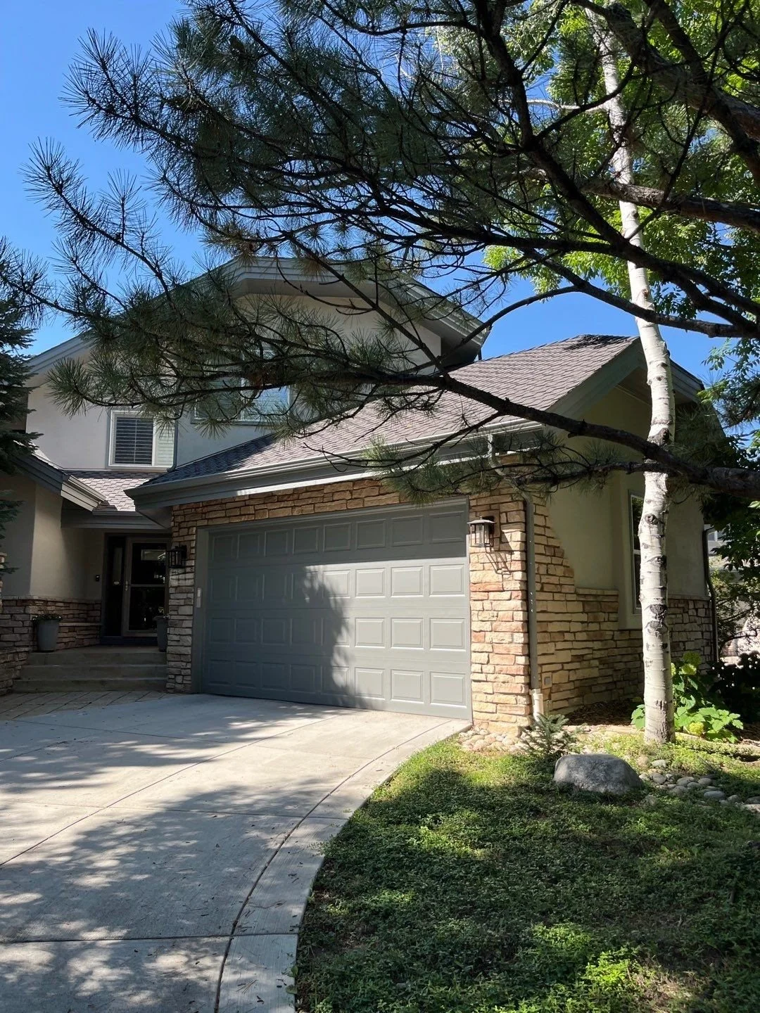 New gutters and downspouts installed around a shaded garage and adjoining roof sections.