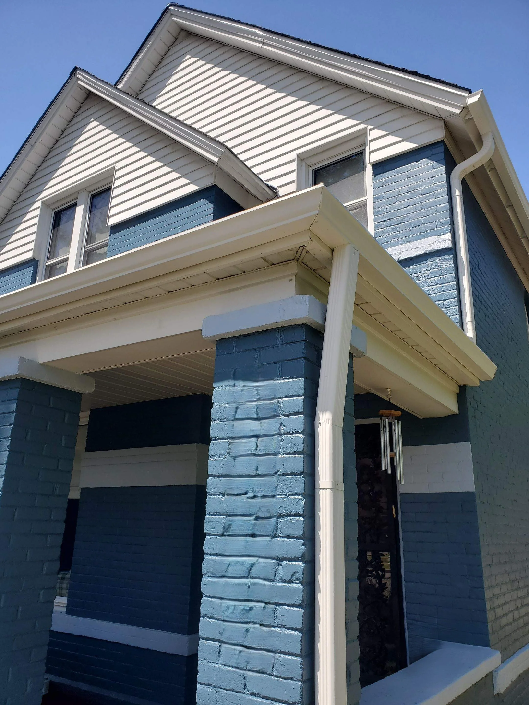 New gutter installation completed around the upper entry roof and adjoining side sections.