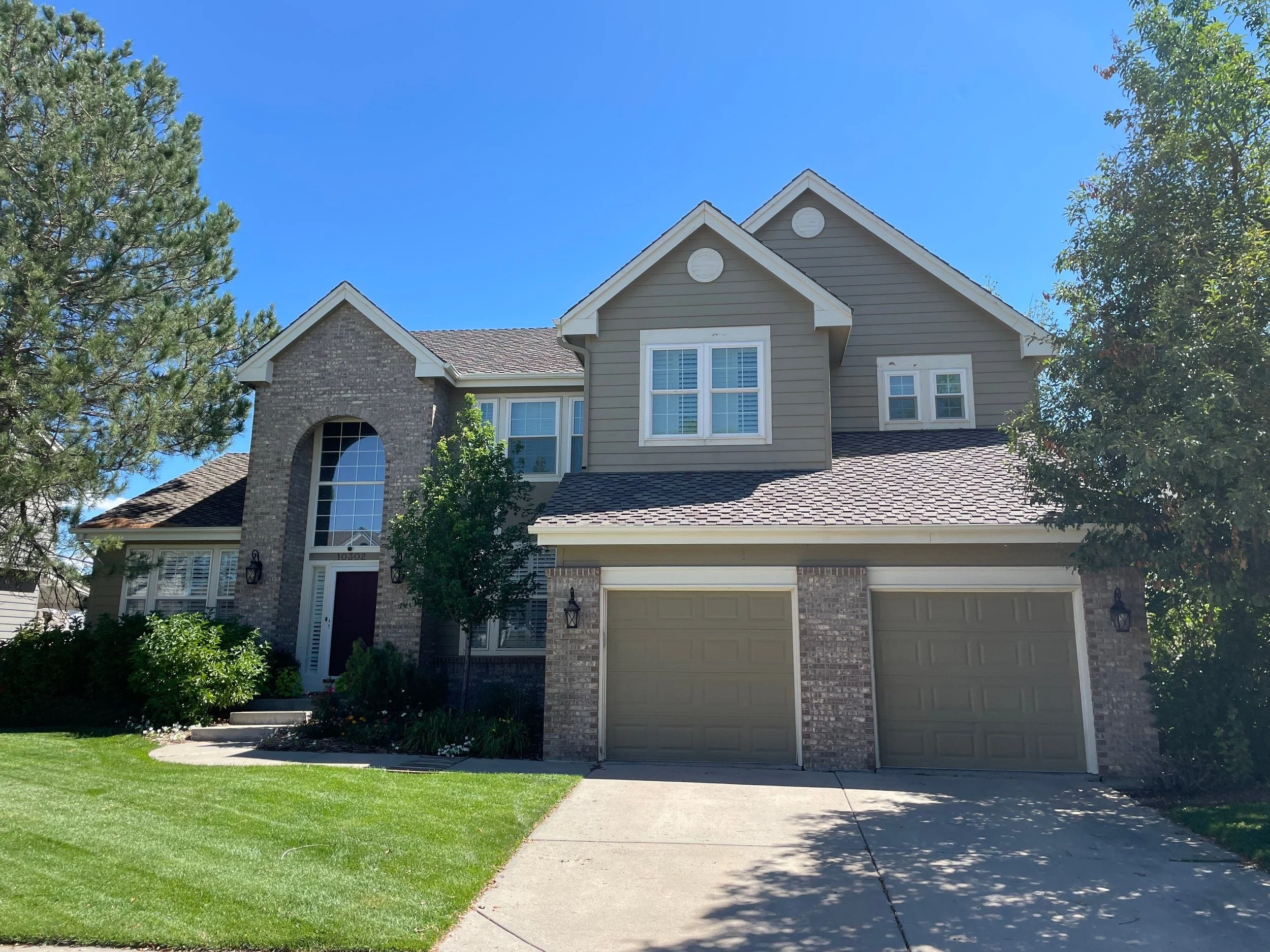 Full gutter replacement completed across the garage, entry, and upper rooflines of a two-story home.