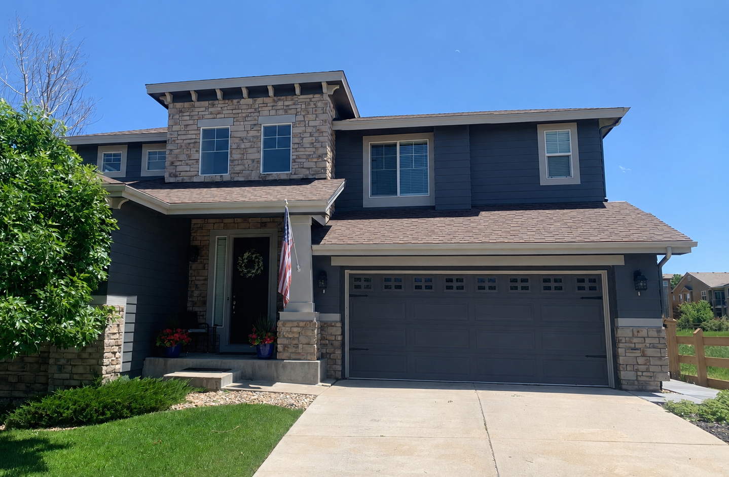 Seamless gutter installation along the front and upper rooflines of a modern two-story home.