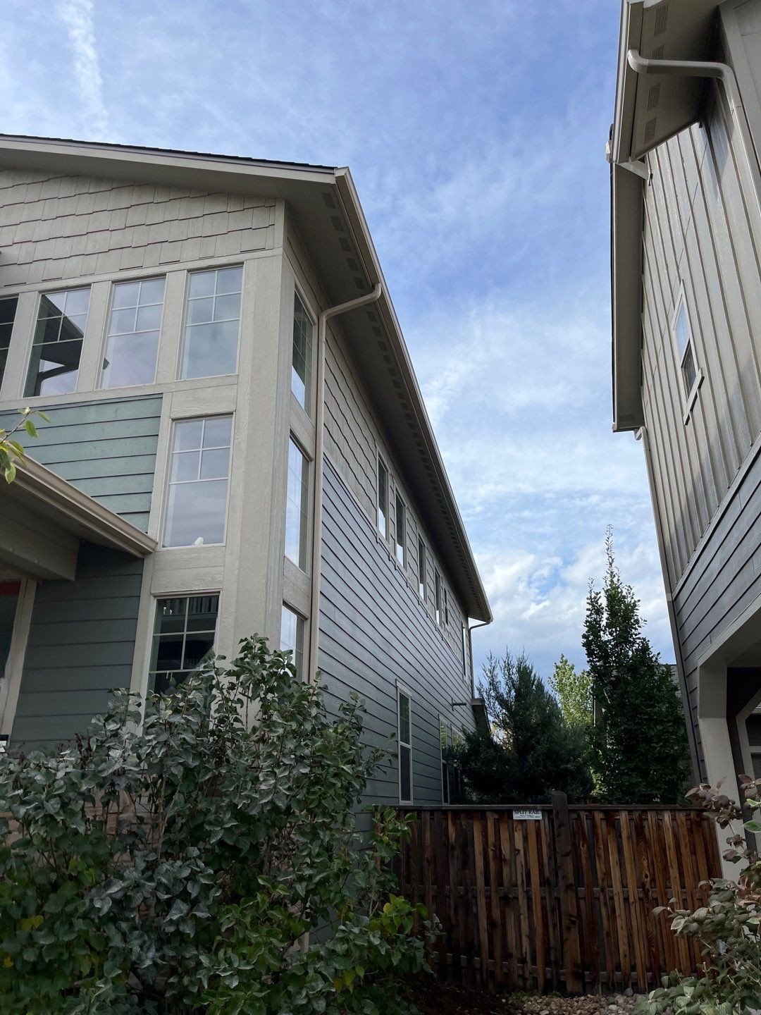 Downspout and seamless gutter installation along the side of a residential home.