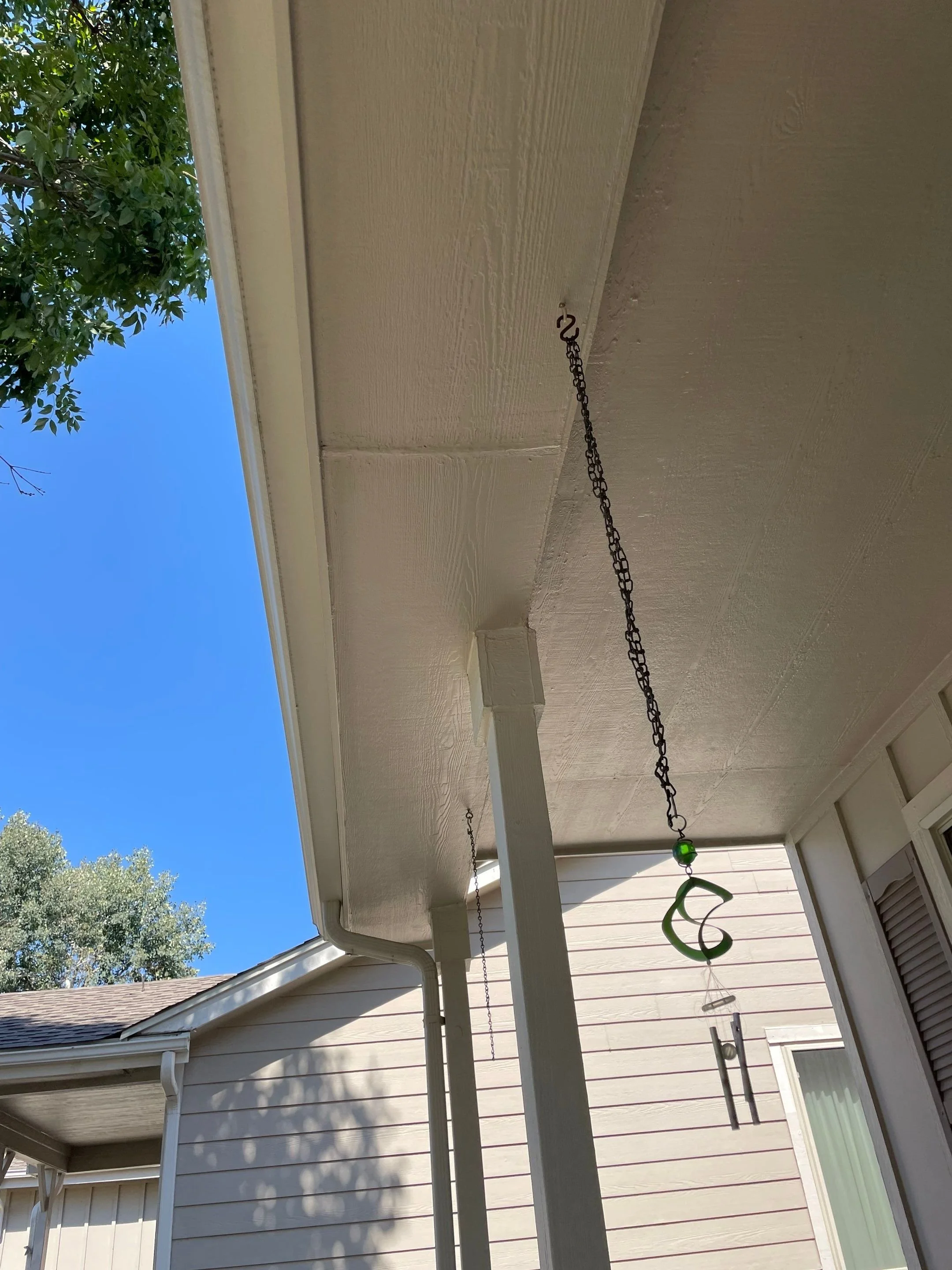 Original front porch gutter before the hail-damaged system was replaced on a Green Mountain home.