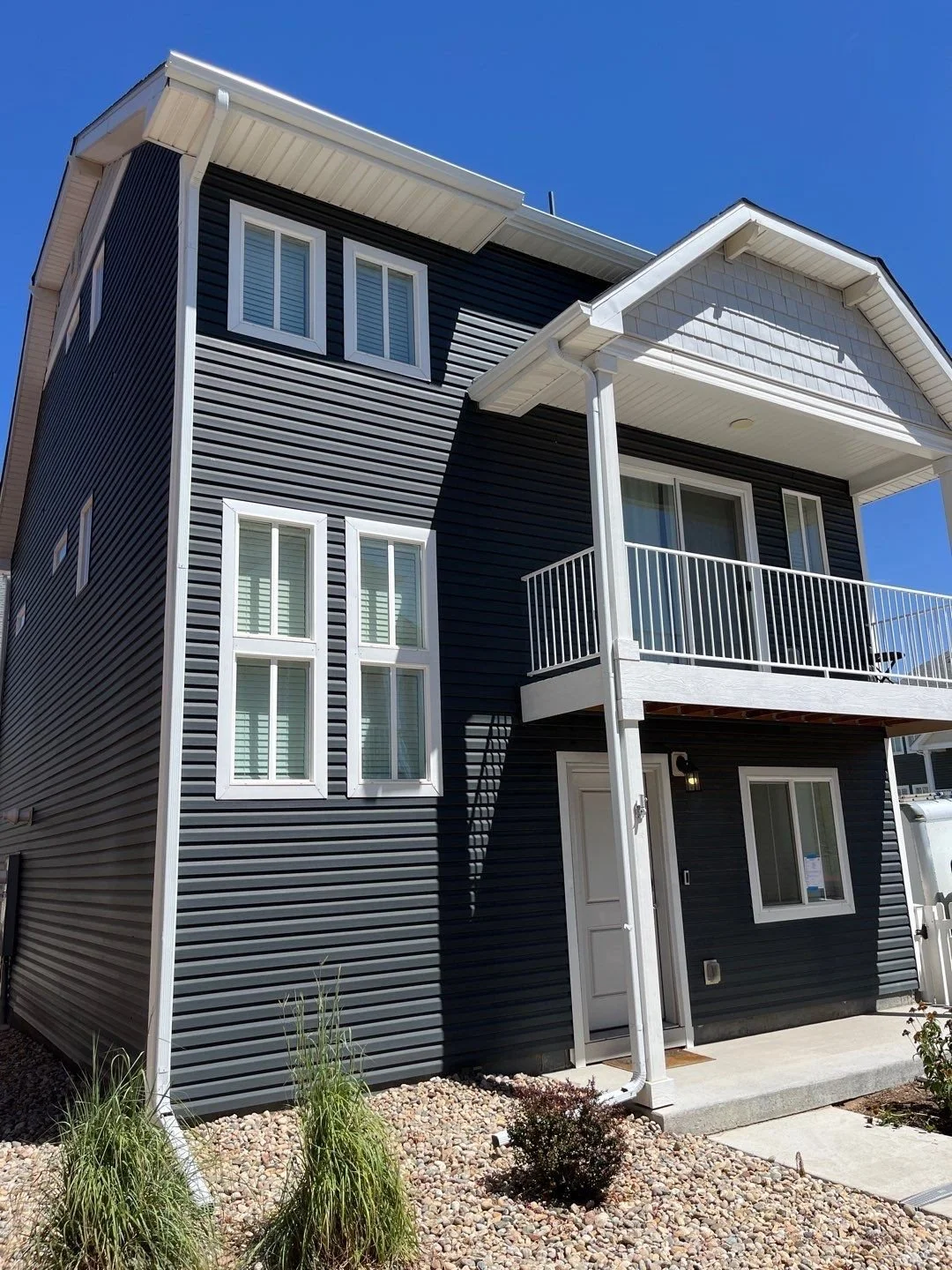 Front exterior of a multi-story home with seamless gutters and downspouts.