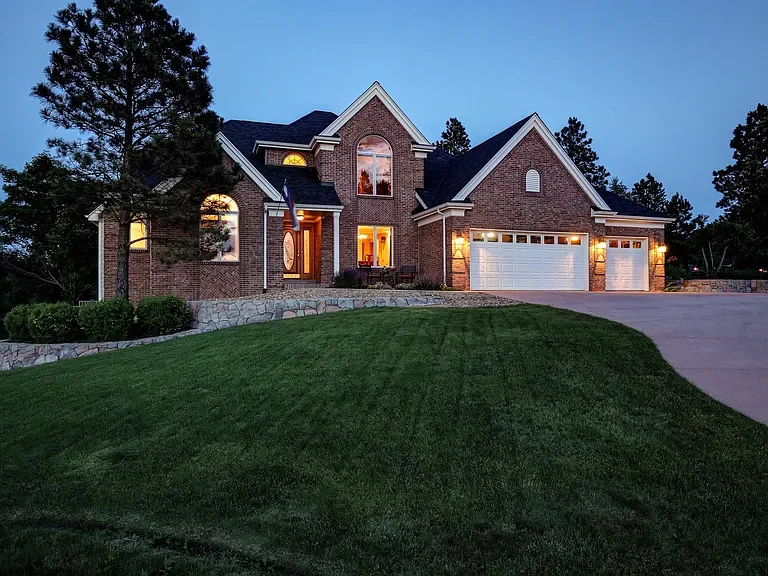 Brick home with new white seamless gutters and downspouts in the Bayou Hills neighborhood of Parker, CO.