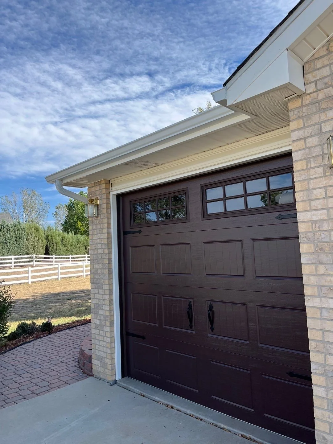 Close-up of seamless gutters and a downspout installed on a residential garage.