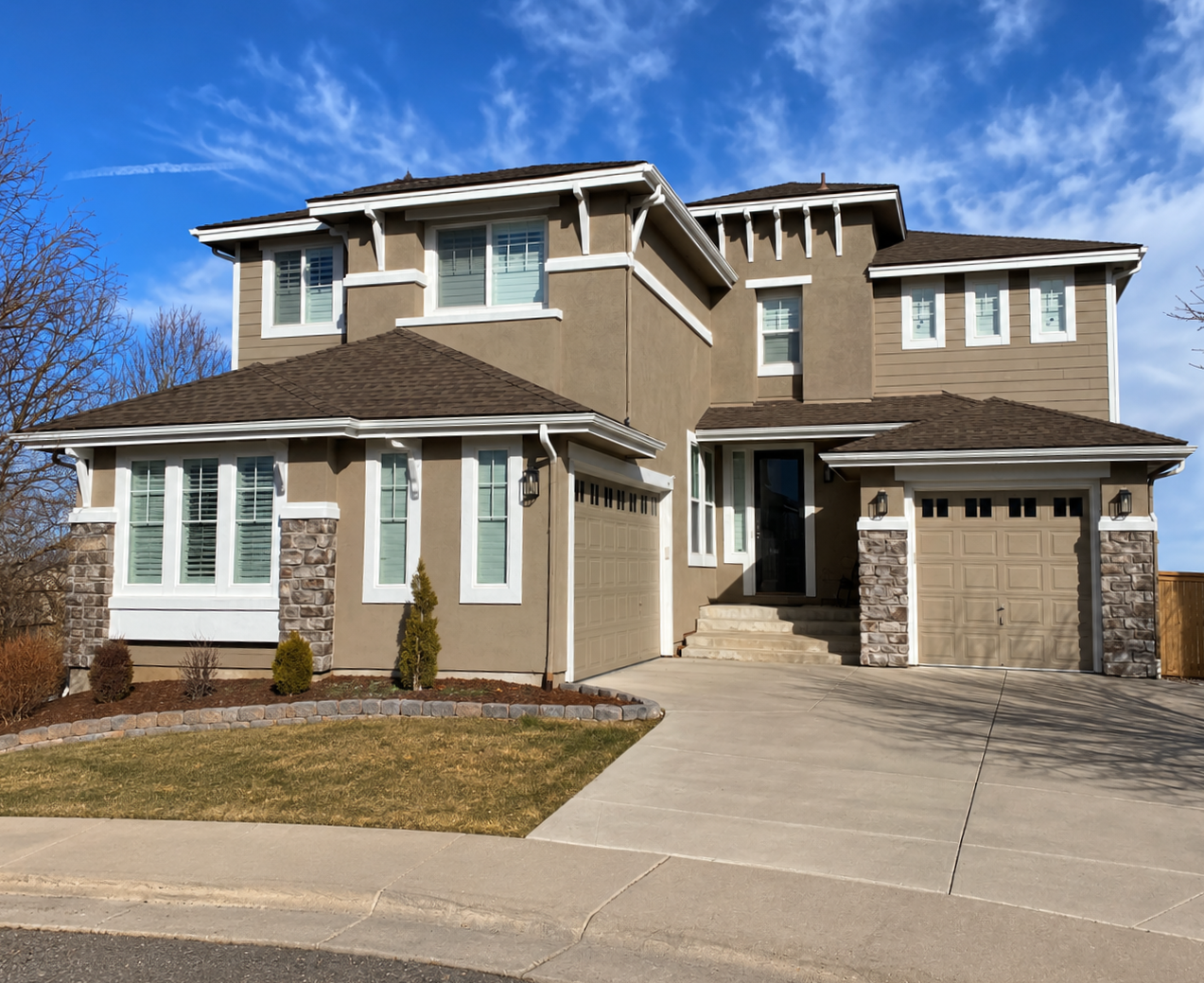 Residential seamless gutter installation completed on a large two-story home with multiple roof sections.