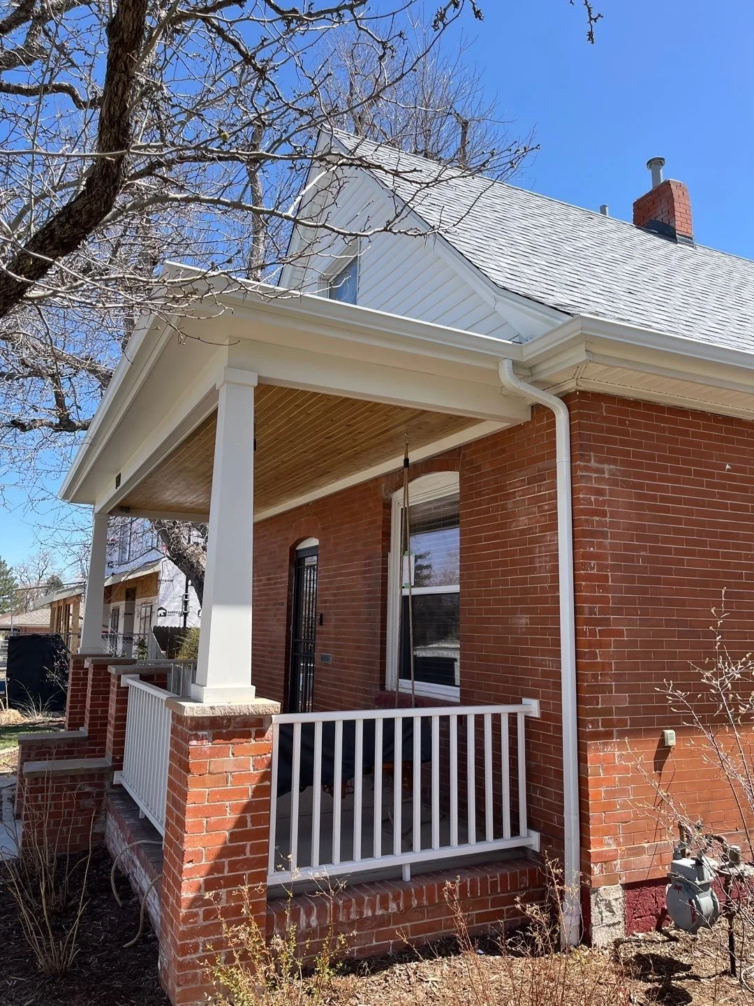 Covered brick entry with a seamless gutter and downspout system.