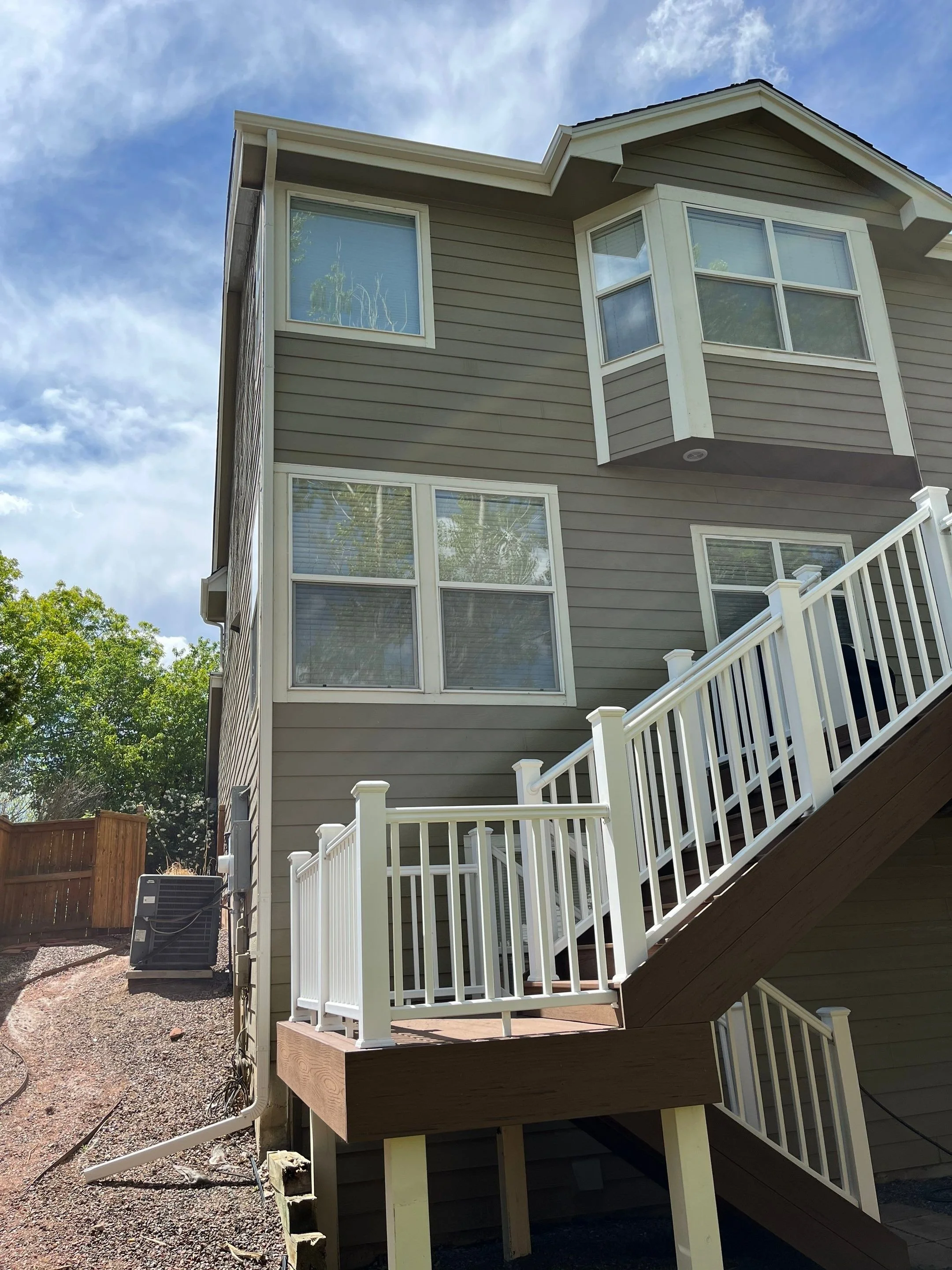 Seamless gutter installation completed around the rear entry and lower roof sections of a multi-story home.