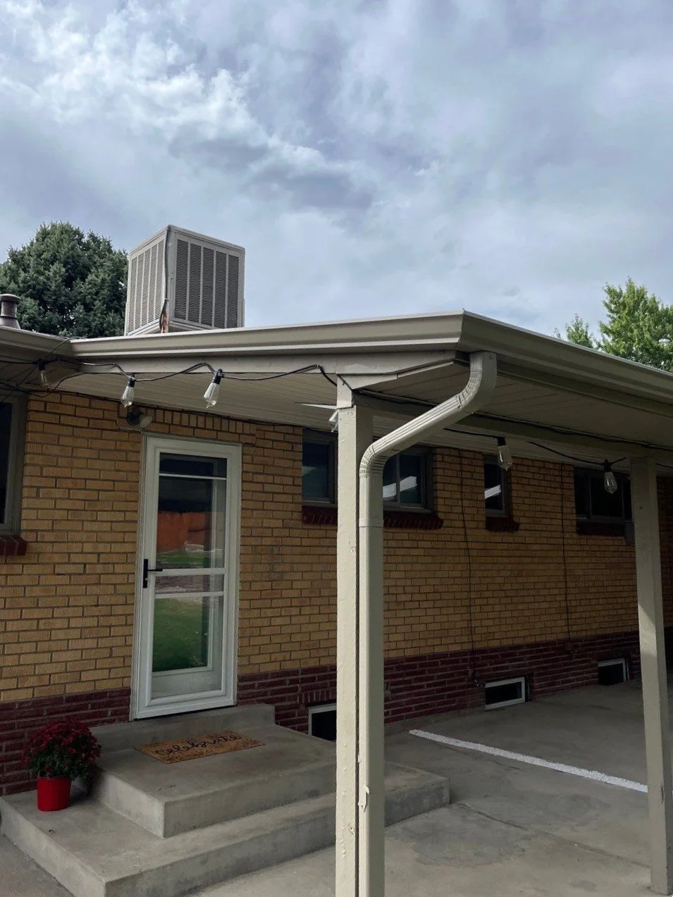 This covered backyard patio received a custom gutter and downspout system to improve drainage along the roof edge.