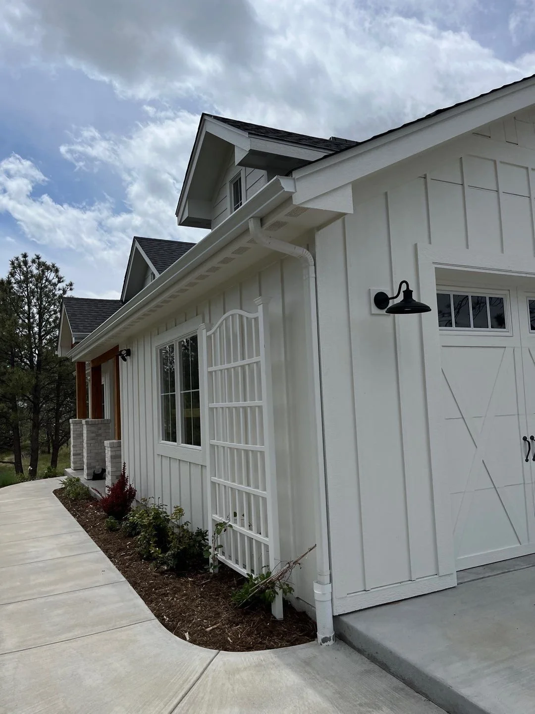 Custom seamless gutters and downspouts installed along the side of a single-story residential addition.