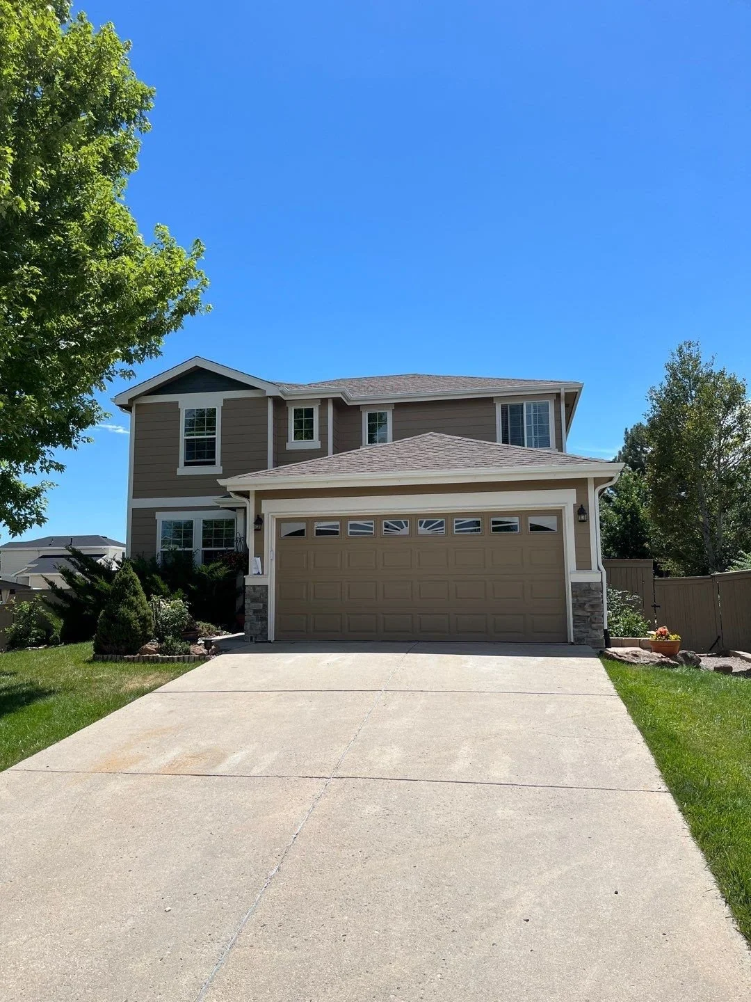 Two-story home with white seamless gutters, downspouts, and an attached garage.