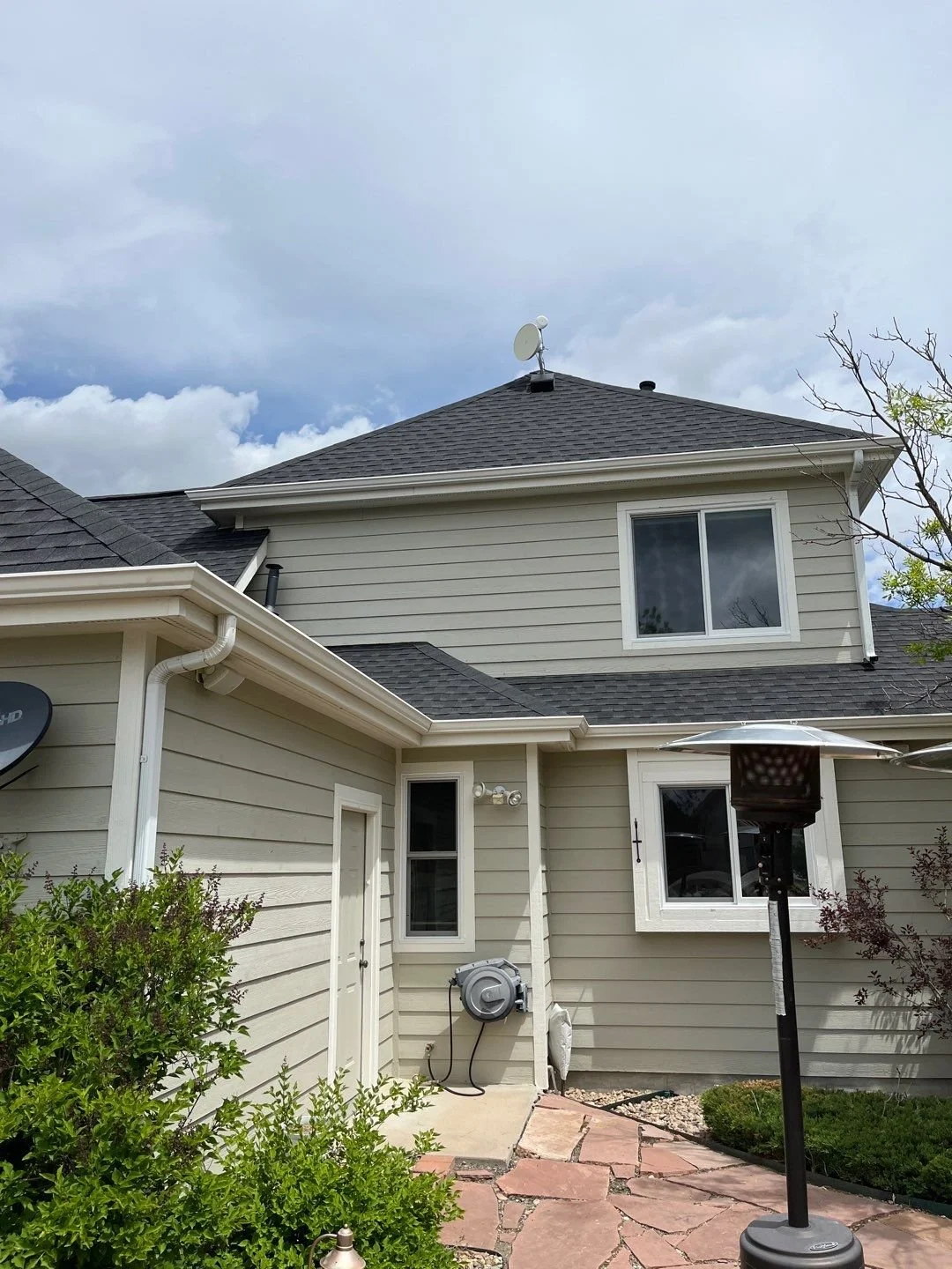 Seamless gutter replacement completed around the front entry and upper roofline of a two-story home.
