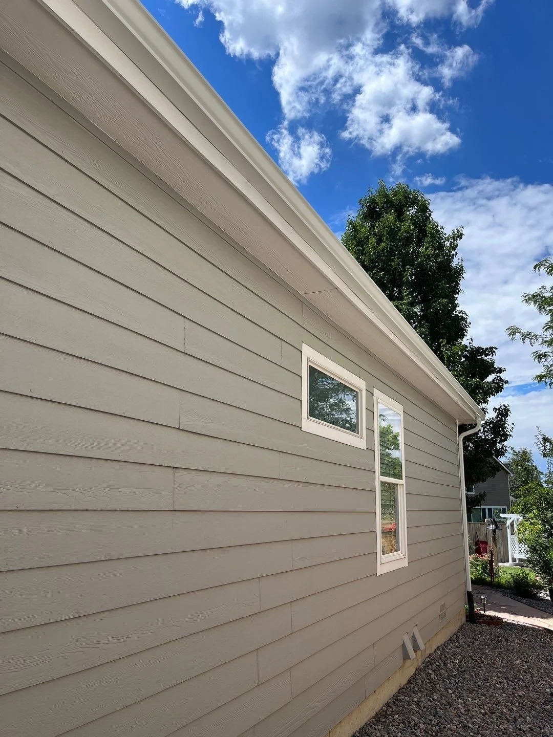 Close-up of a seamless gutter installed along the side roofline of a residential home.