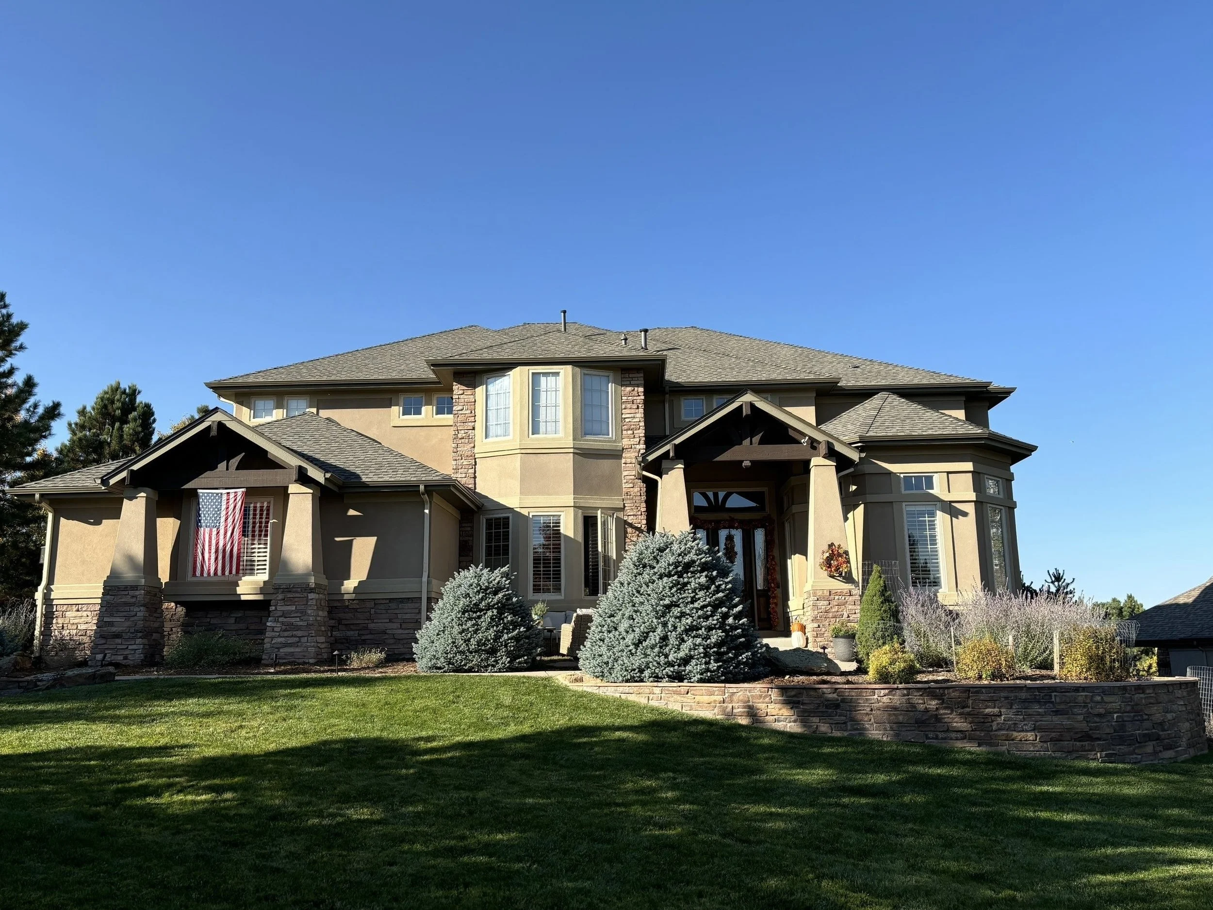 New seamless gutters and downspouts installed on a custom home with multiple rooflines.