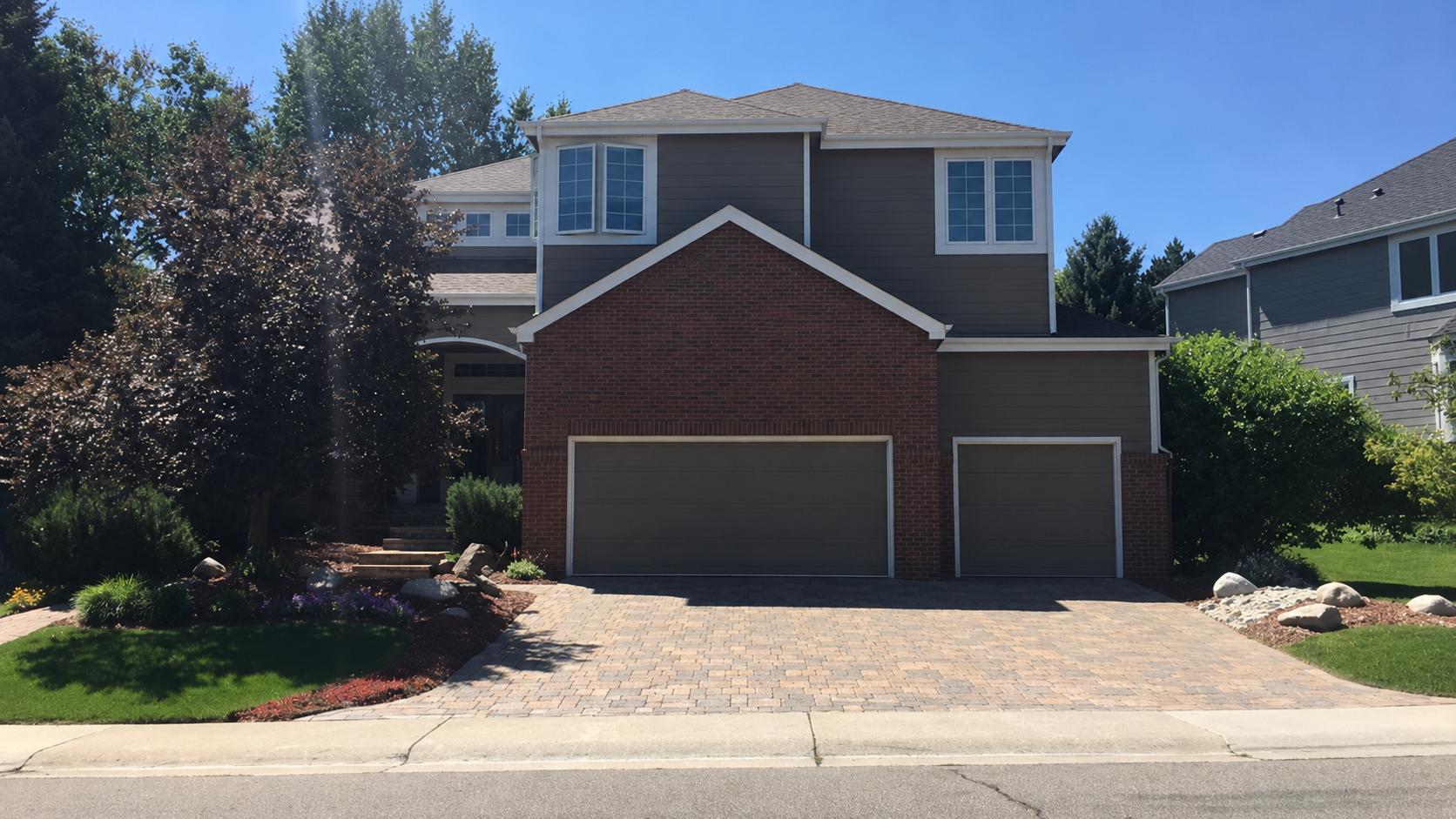 Seamless gutter replacement completed on a rear-facing two-story home with dual garage doors.