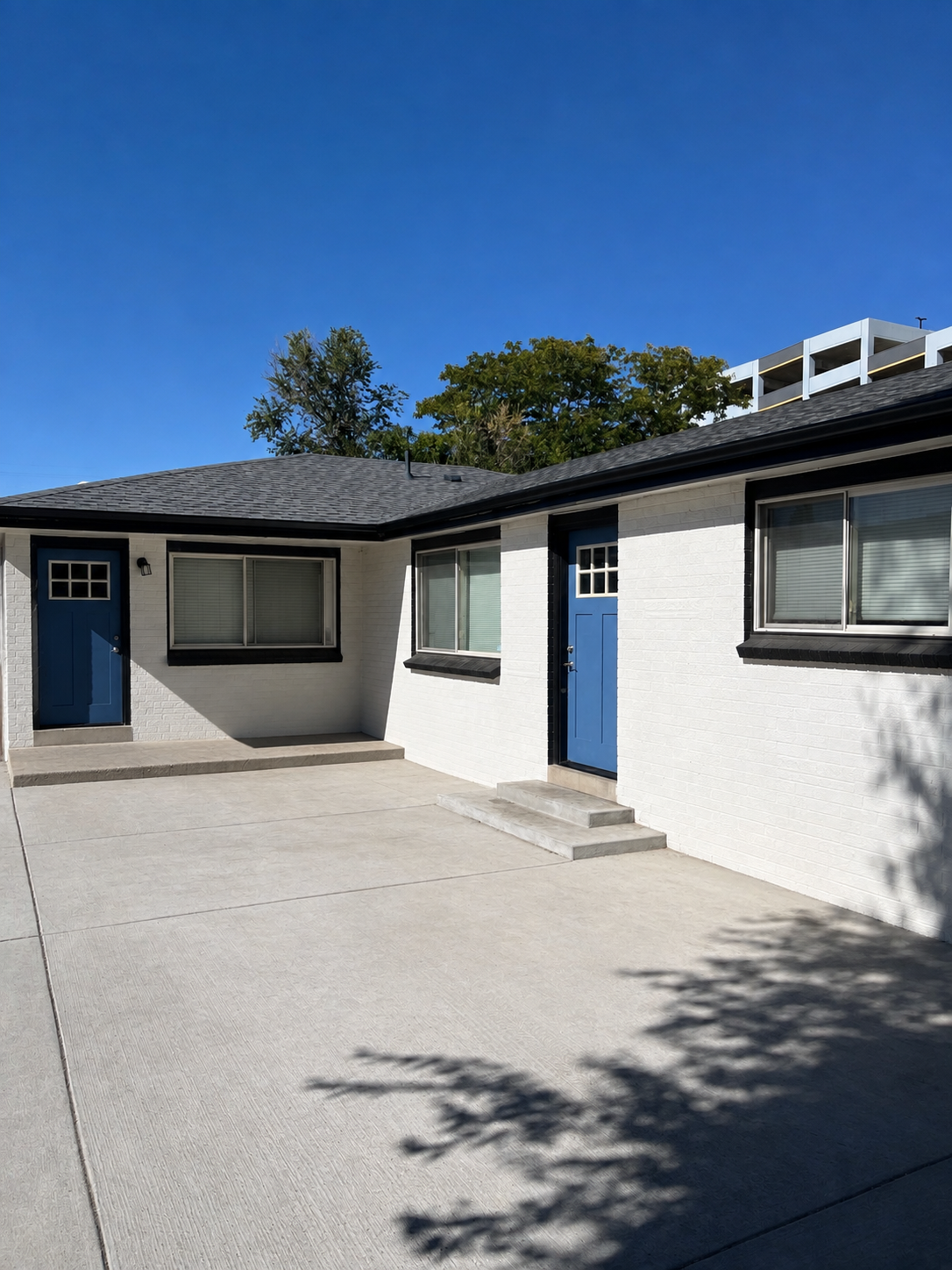 Black 5-inch seamless aluminum gutters installed on a white brick home in Aurora, CO.