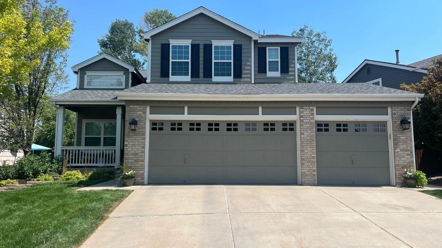 Full gutter replacement installed above the garage and across the front roofline of a gray home.
