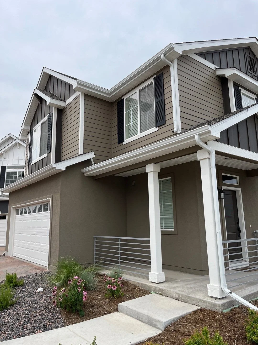 Completed residential gutter replacement with new seamless gutters and downspouts on a multi-story home.