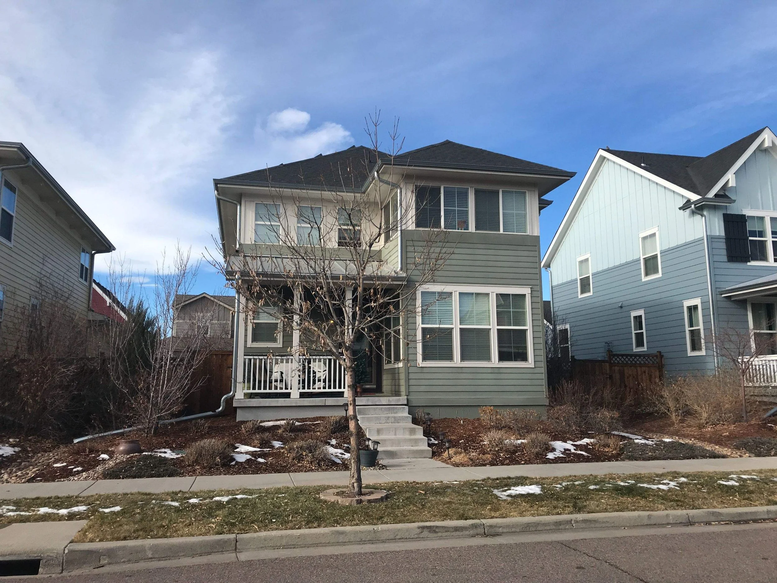 Two-story home with a seamless gutter system and downspouts installed along the front exterior.