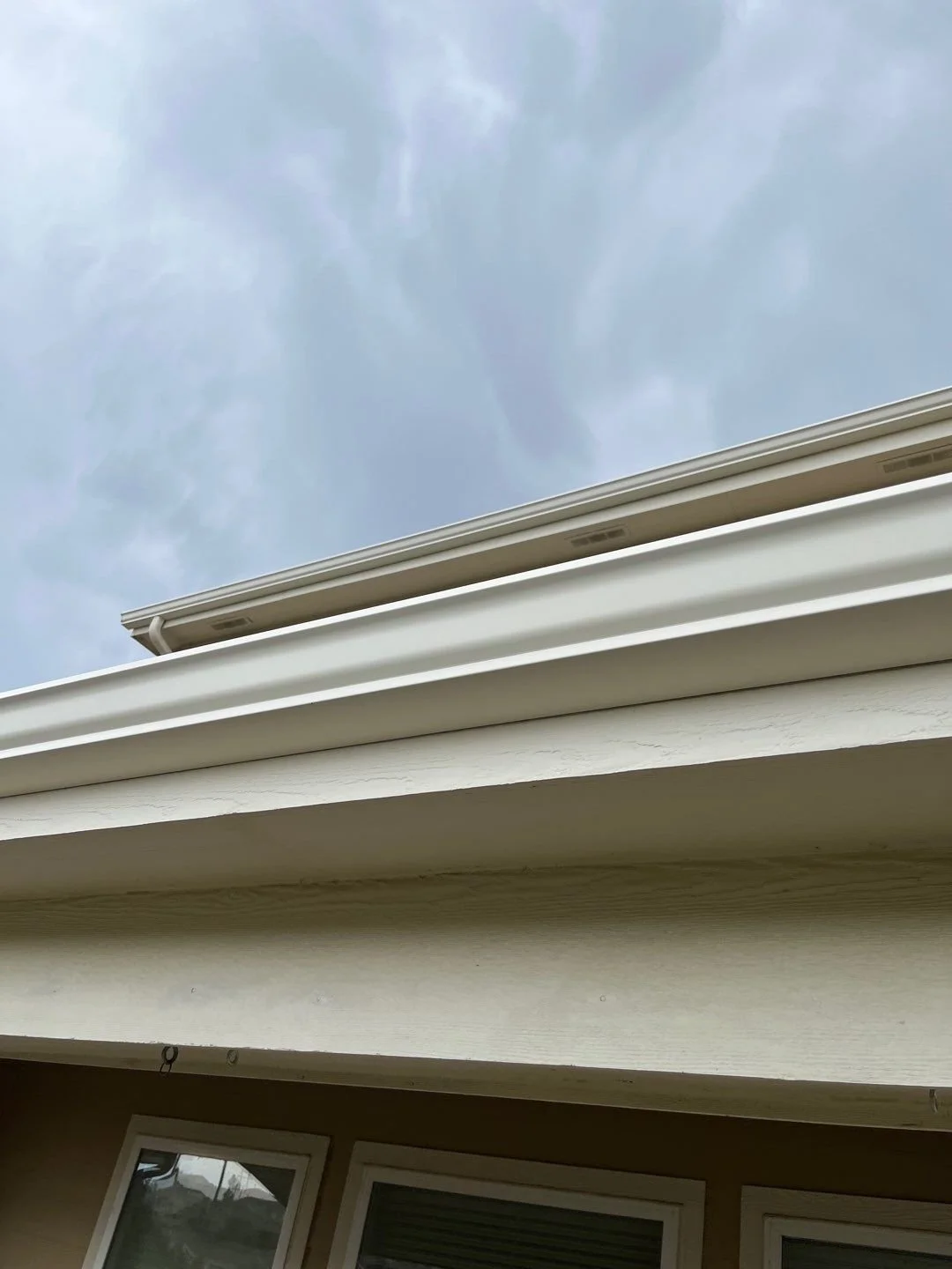 Close-up of a linen seamless gutter installed along a residential roofline.