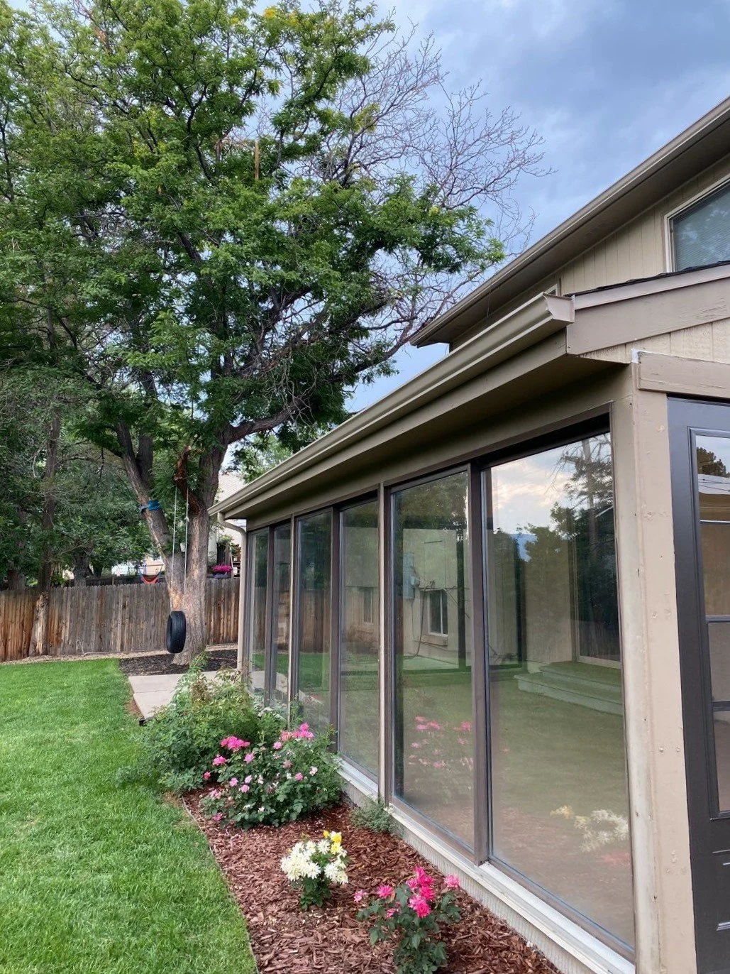 Wicker seamless gutter and downspout installed beside a glass sunroom in Lakewood.