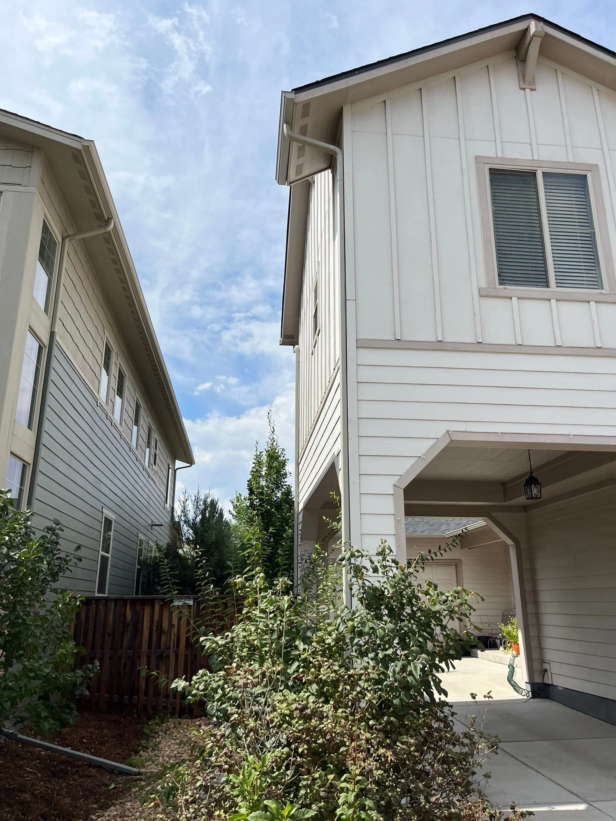 Downspout installed between two closely spaced residential walls.