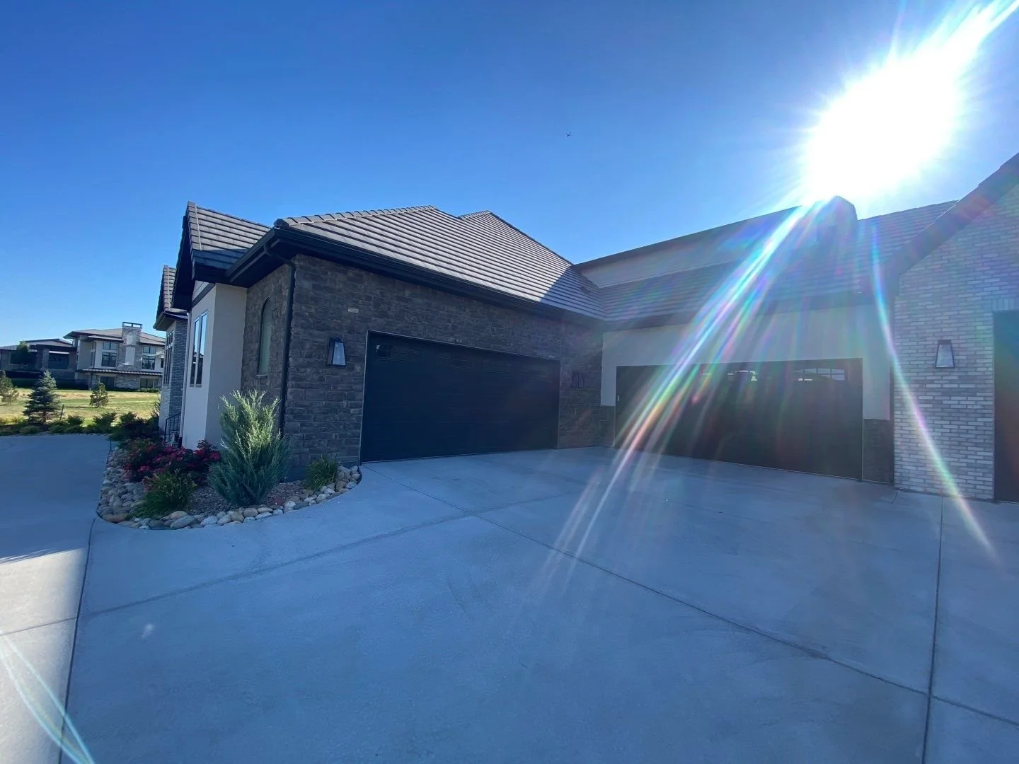 Seamless gutters and downspouts installed on a modern home with an attached garage.