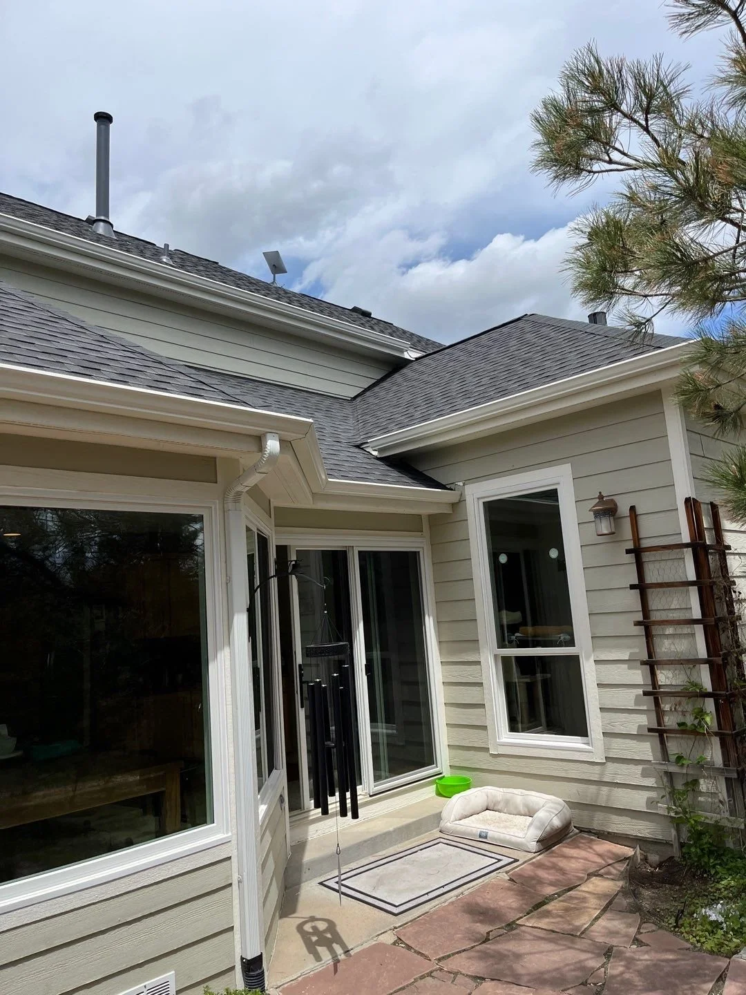 New gutters and downspouts installed around a covered entry with multiple adjoining roof sections.