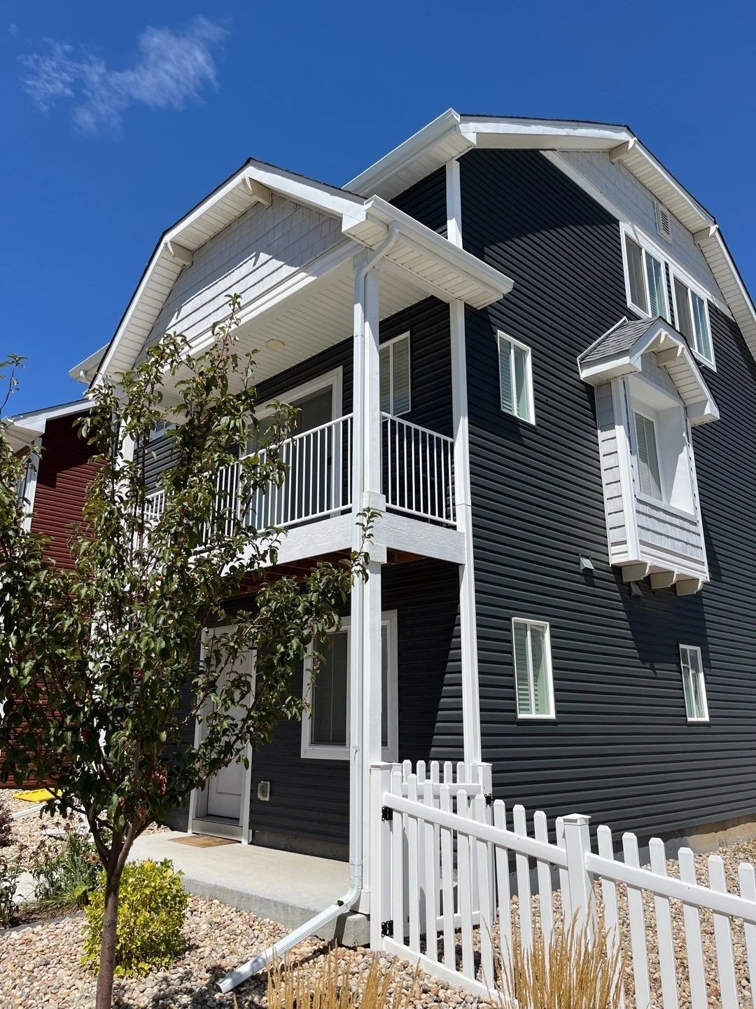 Seamless gutters and downspouts installed on a multi-story home with a covered porch.