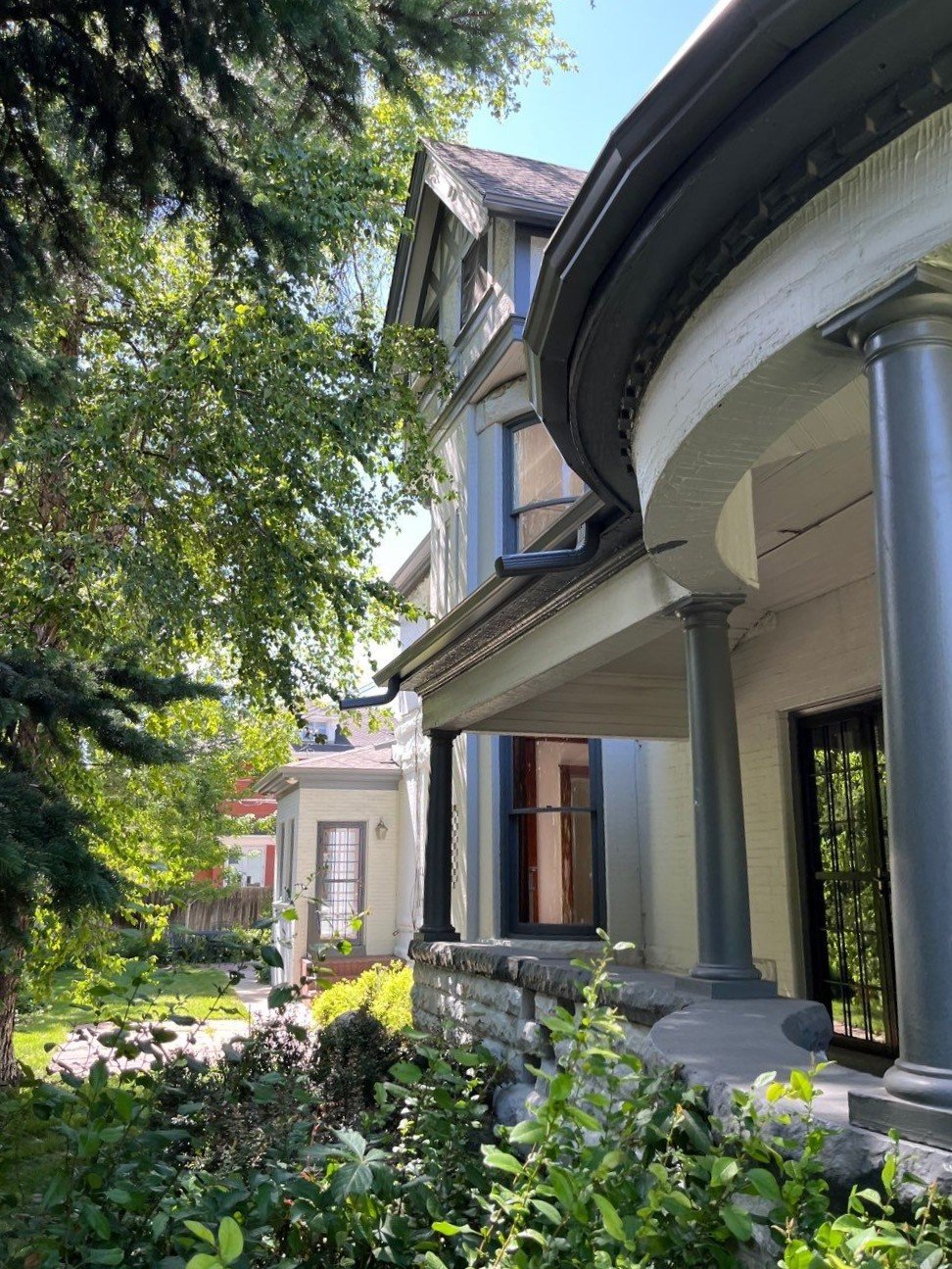 Completed turret gutter and charcoal gray downspout on the Denver home.