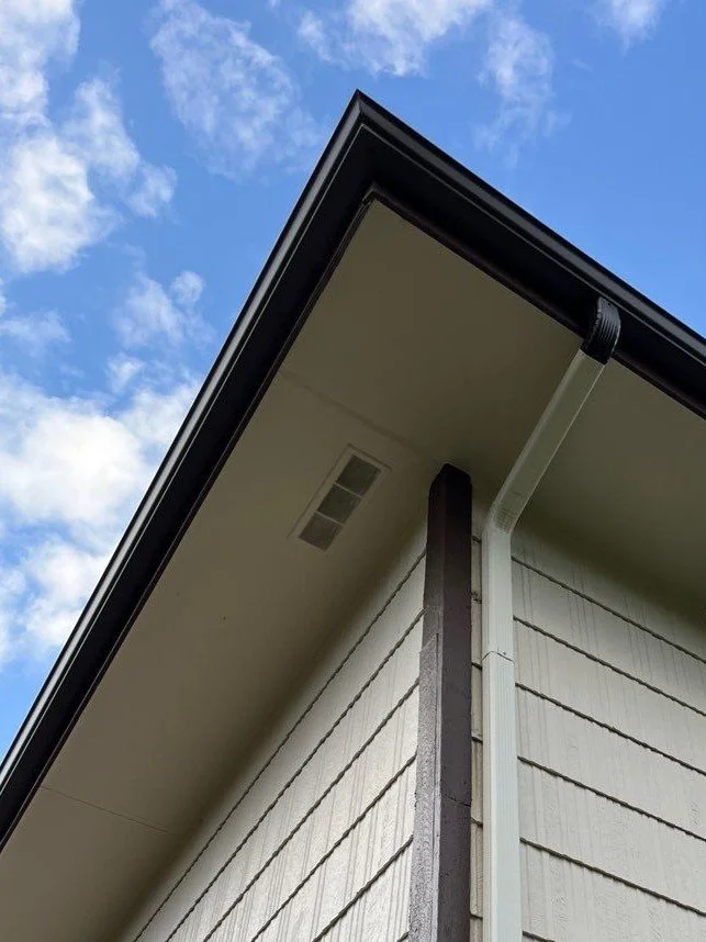 A new gutter and downspout system was installed beneath the upper roofline of this two-story home.