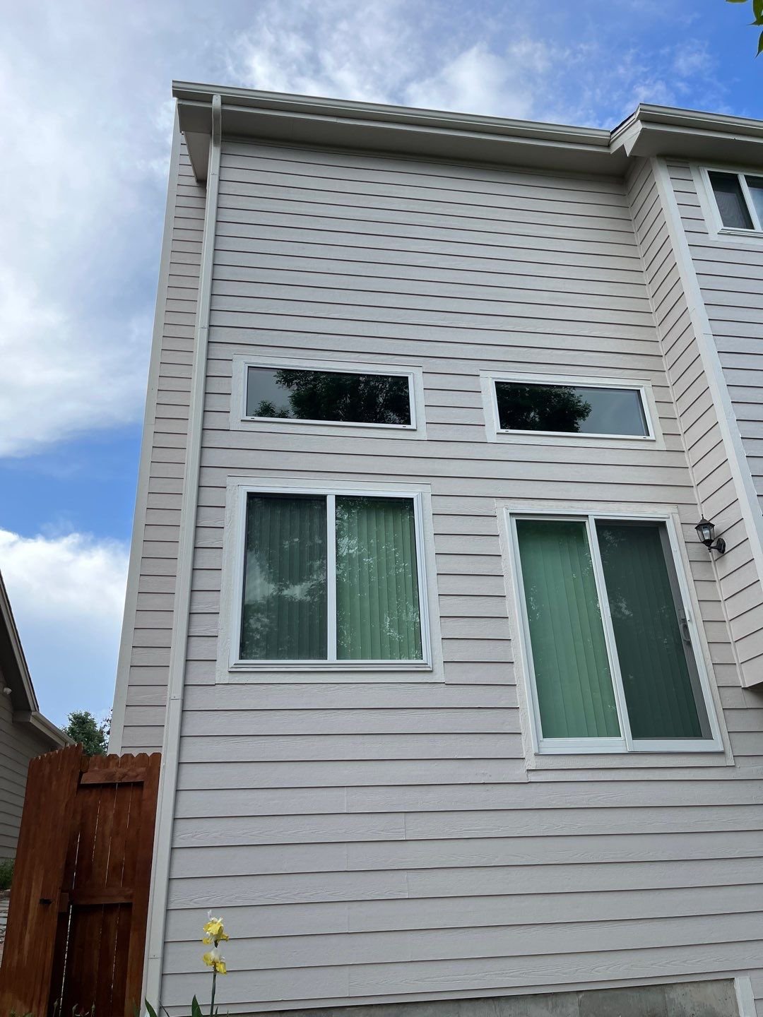 New linen seamless gutter fitted along the upper rear roofline of a three-story Lakewood home.