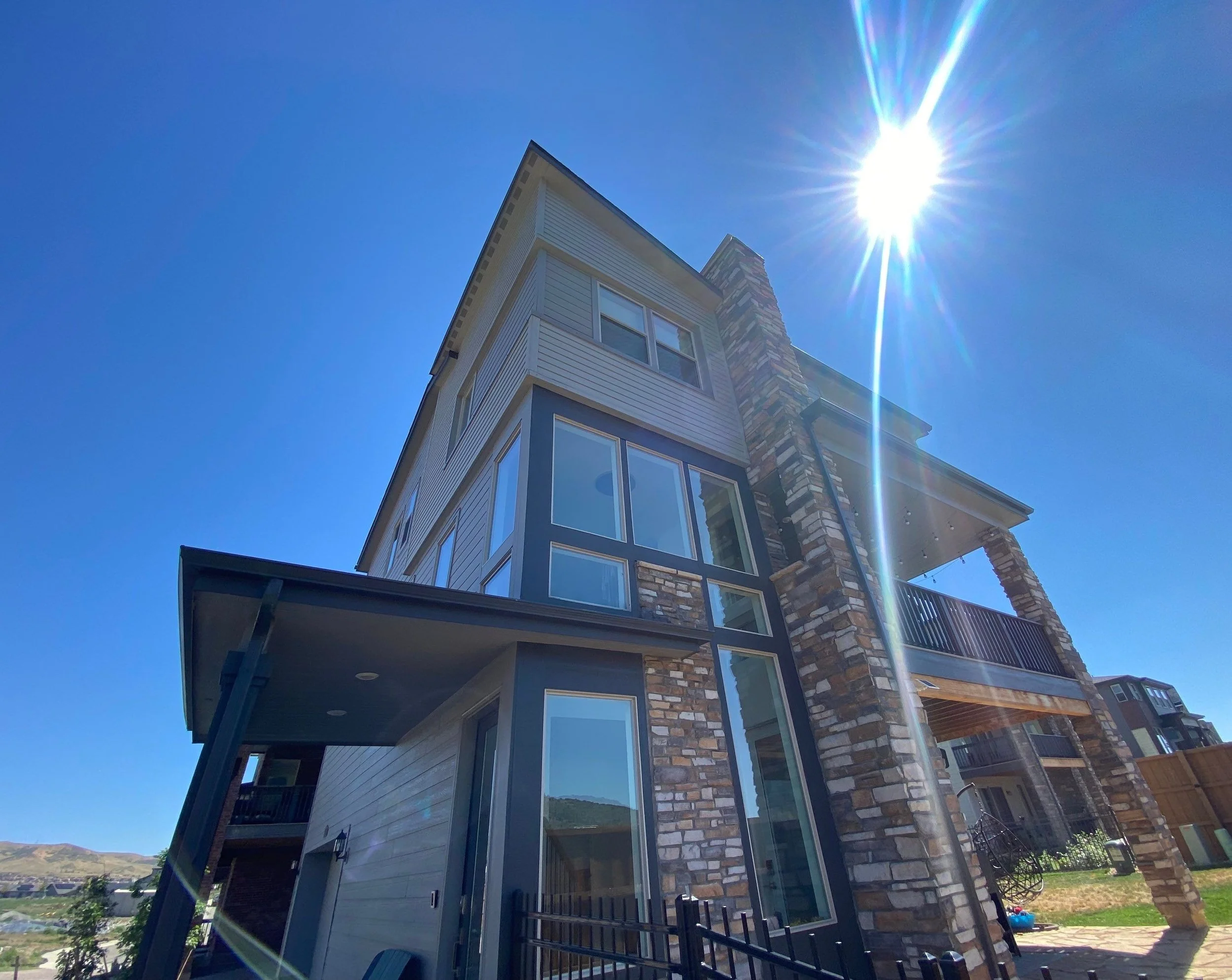 Complete gutter replacement designed around the tall, intersecting rooflines of a modern multi-story home.