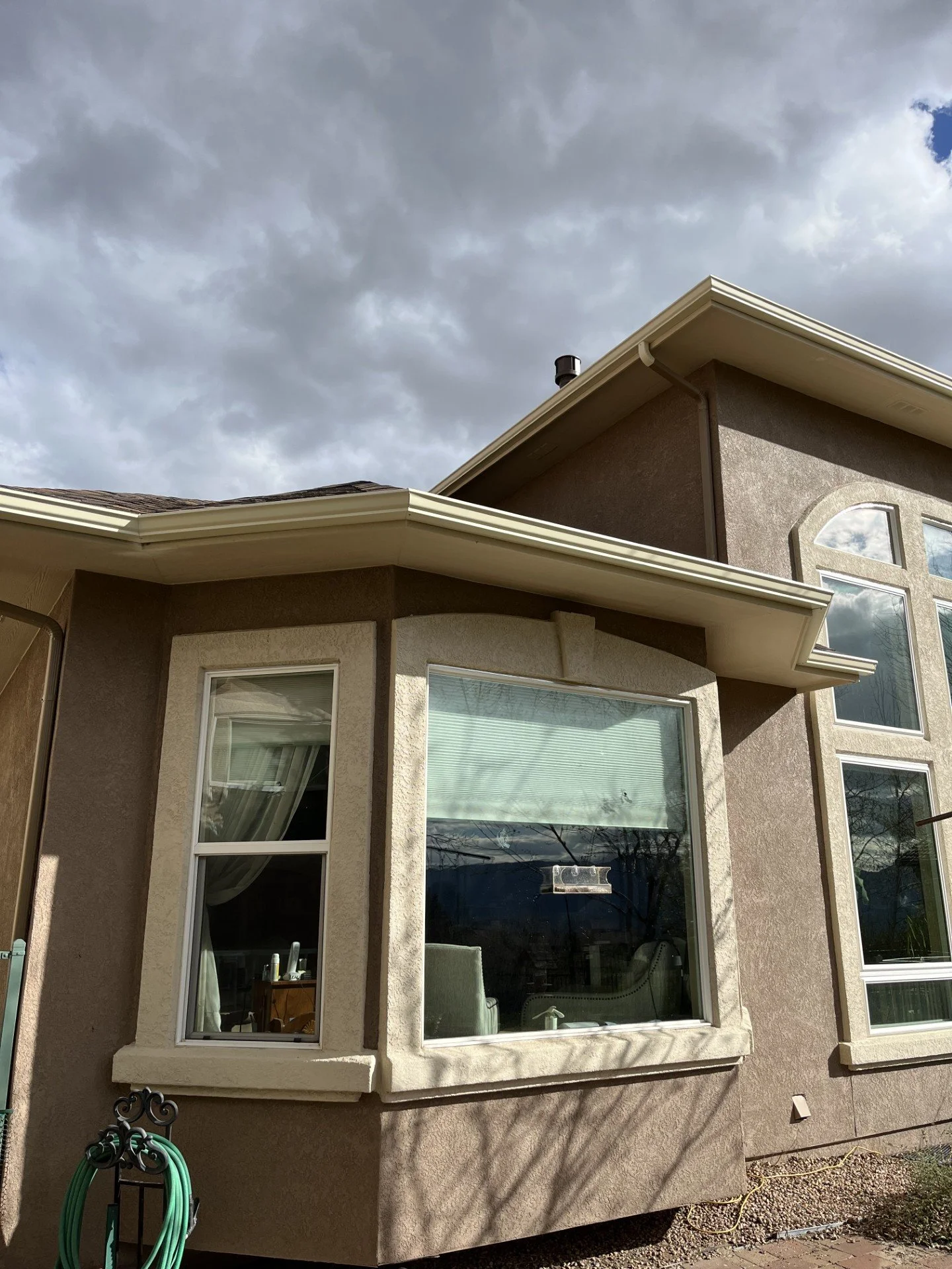 Bay window with a custom seamless gutter installed along the upper roof edge.