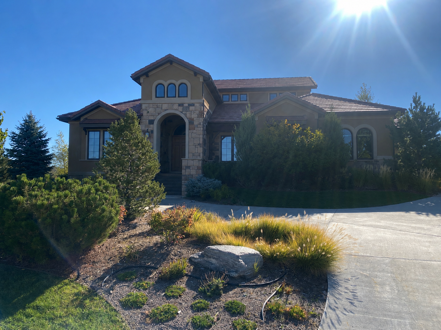 Large custom home with seamless gutters, downspouts, and landscaped front grounds in the Denver Metro area.