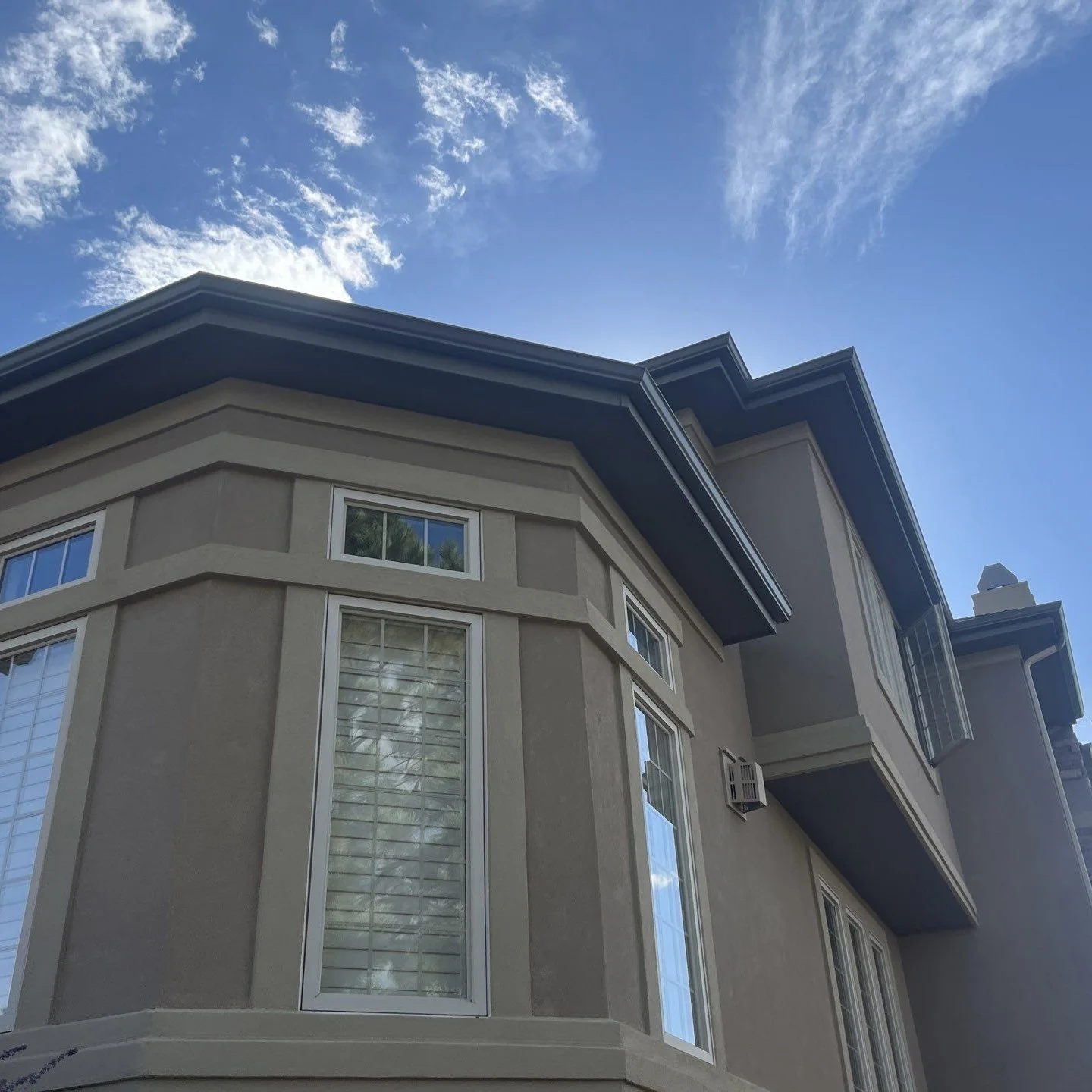 Custom seamless gutter replacement installed around a projecting bay window on a residential home.