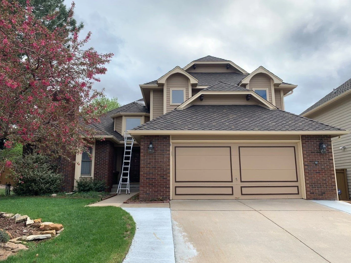 Two-story home with seamless gutters, downspouts, and an attached garage.