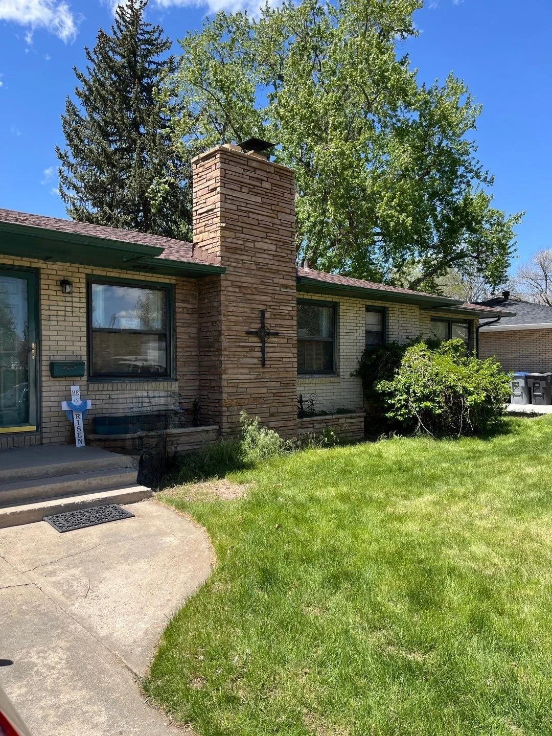 New gutters and downspouts complete the roofline of this established brick home.