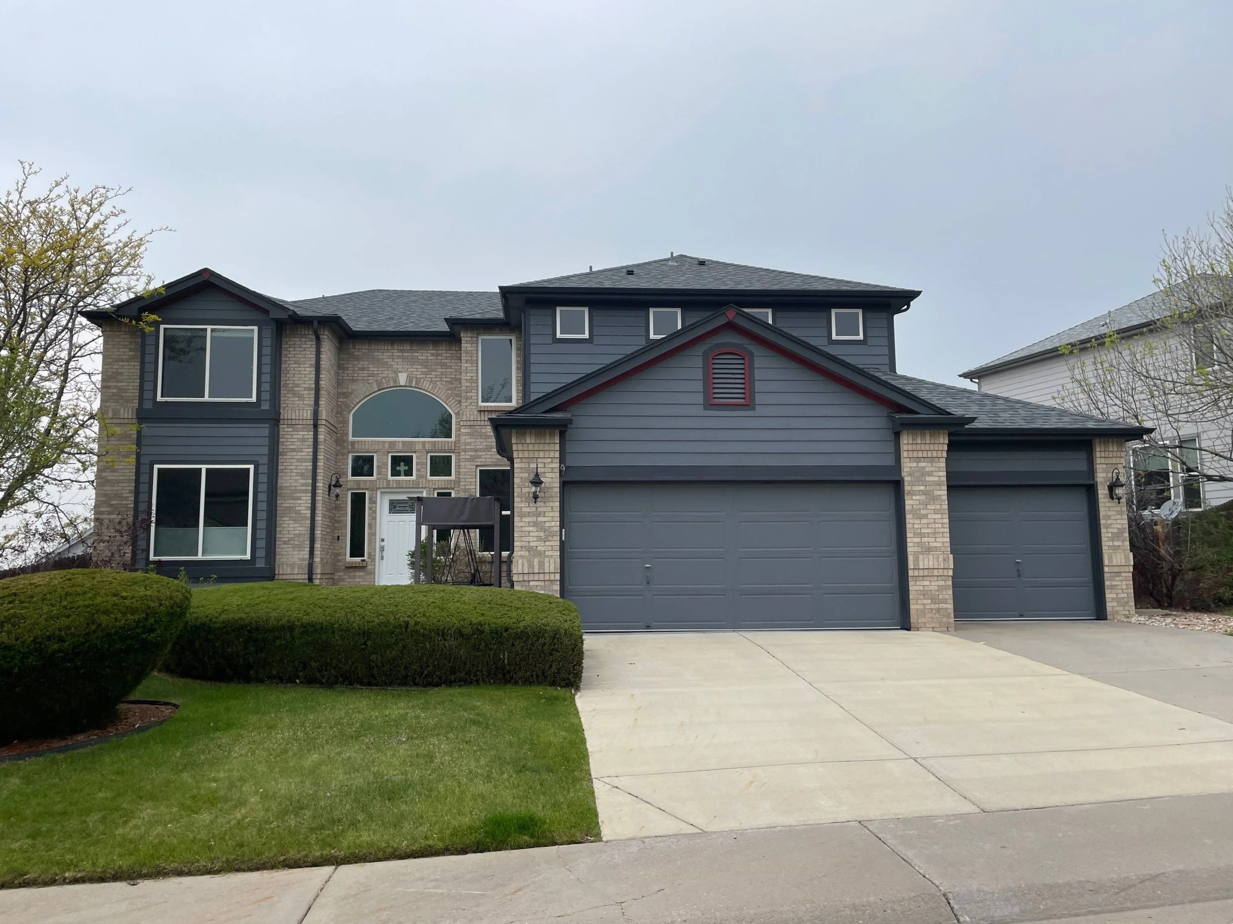 Two-story home with seamless gutters, downspouts, and an attached garage in the Denver Metro area.