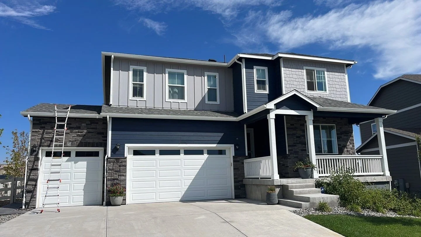 Dark blue two-story home with white seamless gutters and downspouts in the Denver Metro area.