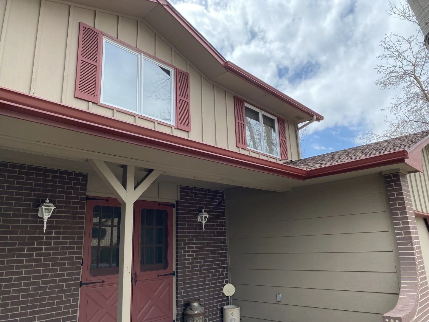 Residential gutter replacement completed around a covered entry and adjoining roof edges.