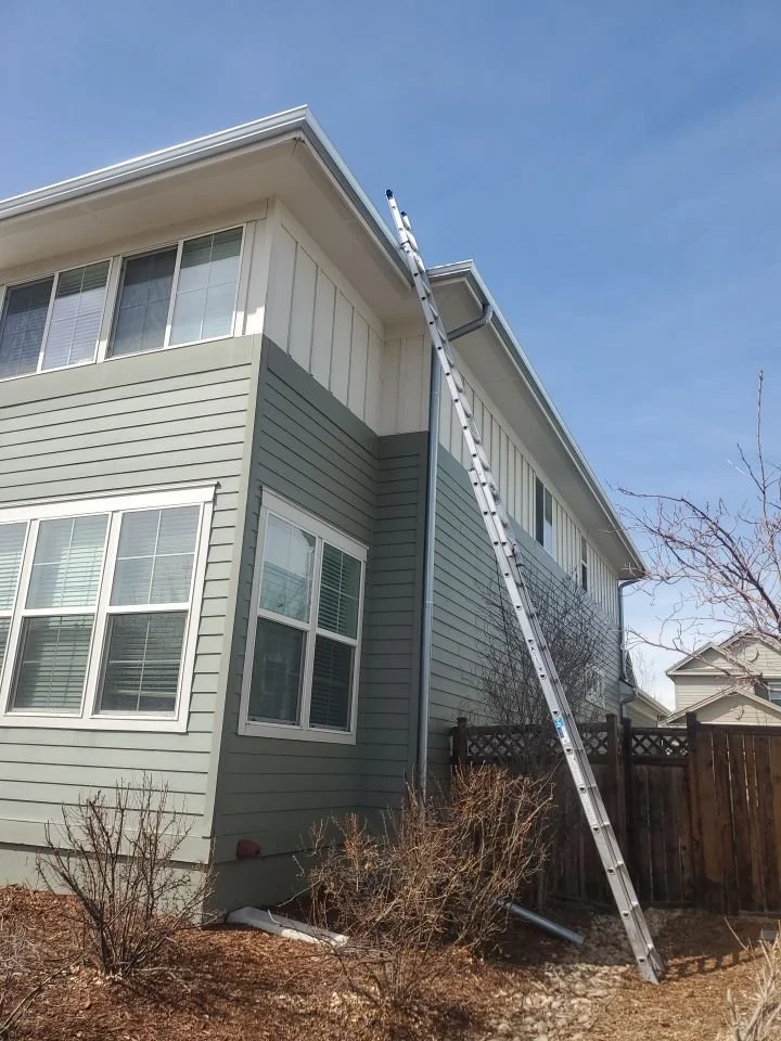 Long downspout installed along the side of a two-story home.