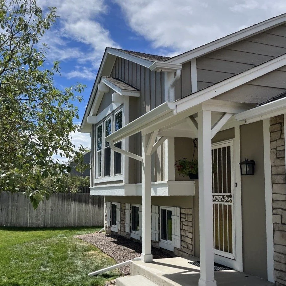 Custom seamless gutter installation around the covered porch of a two-story home.