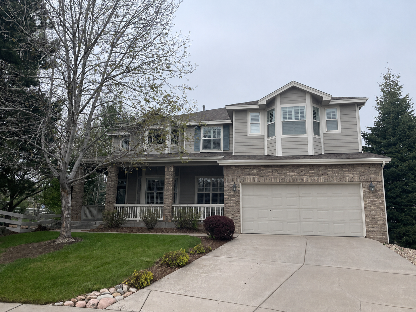 Two-story home with seamless gutters, downspouts, and an attached garage in an established Denver Metro neighborhood.